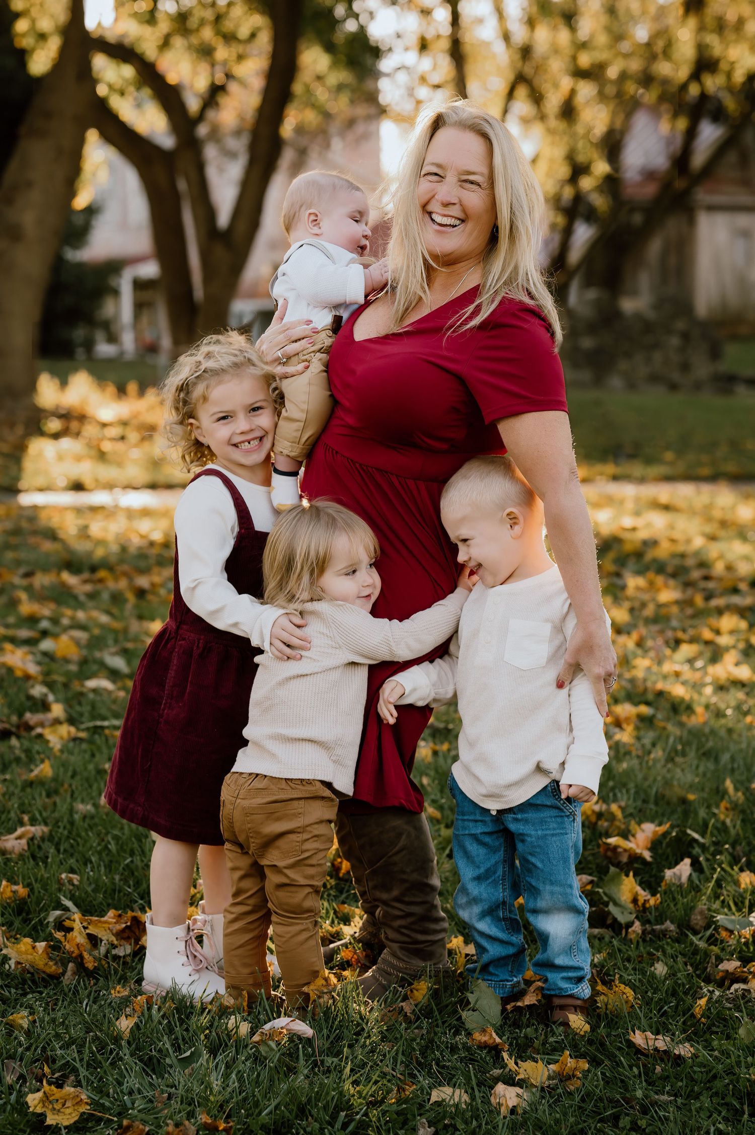 Joyful outdoor family moment captured in an autumn garden with fallen leaves.