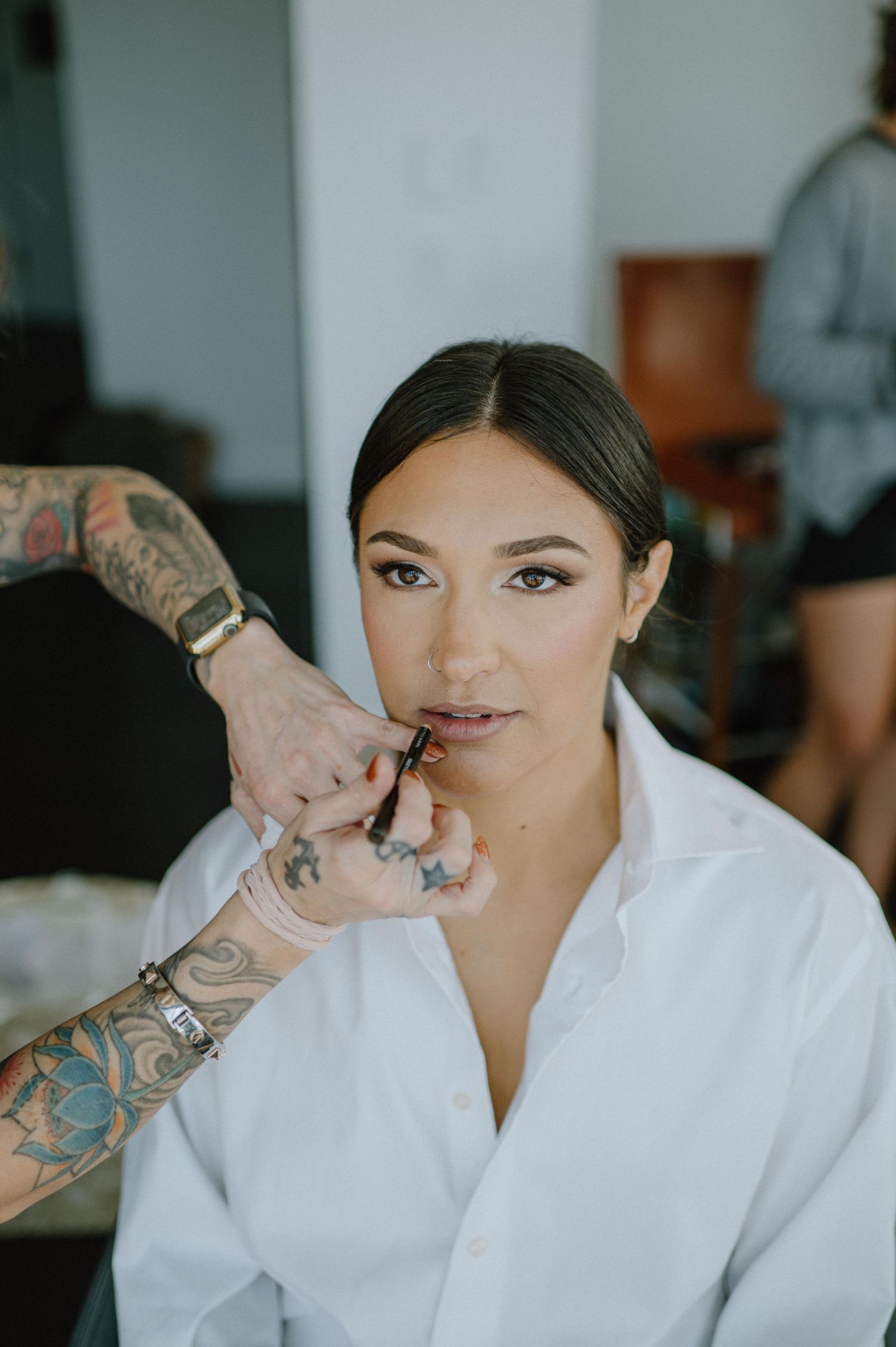 Getting ready for the wedding with makeup being applied while wearing a white robe.
