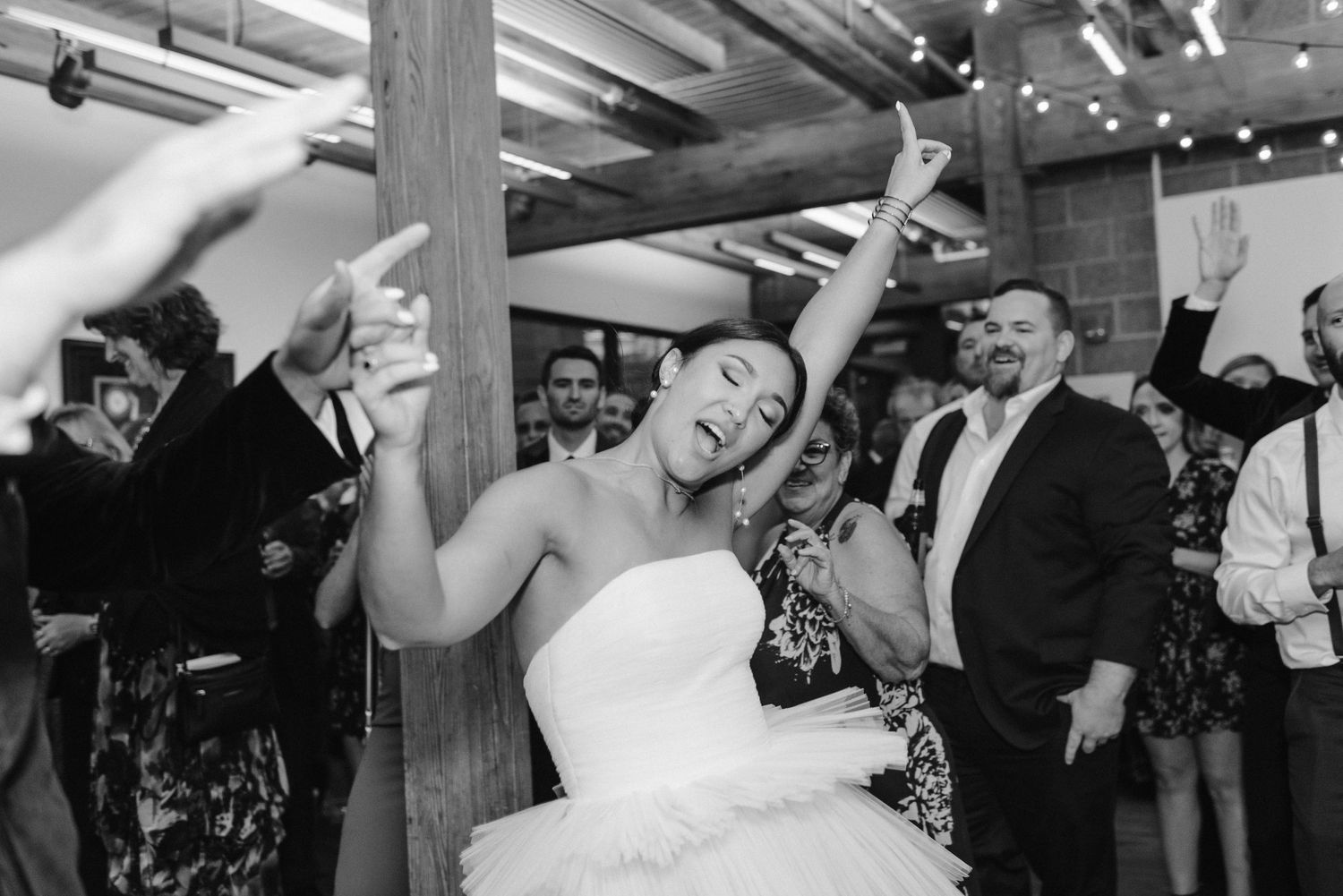 A celebratory dance moment captured in black and white during a wedding reception.