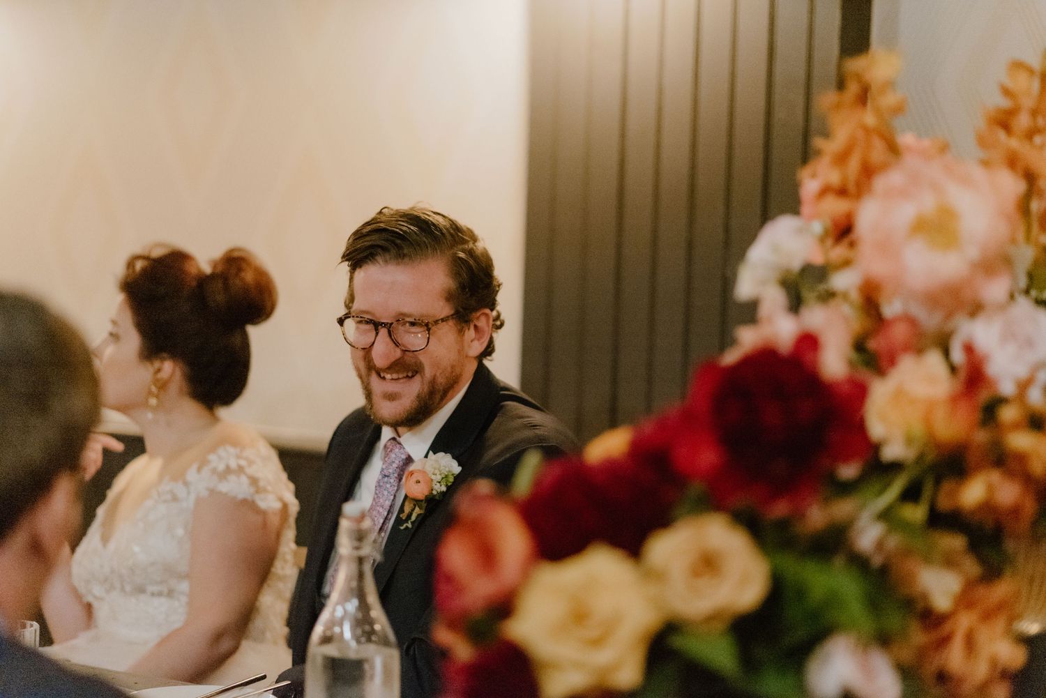 Wedding reception scene with colorful floral arrangements decorating an indoor venue.