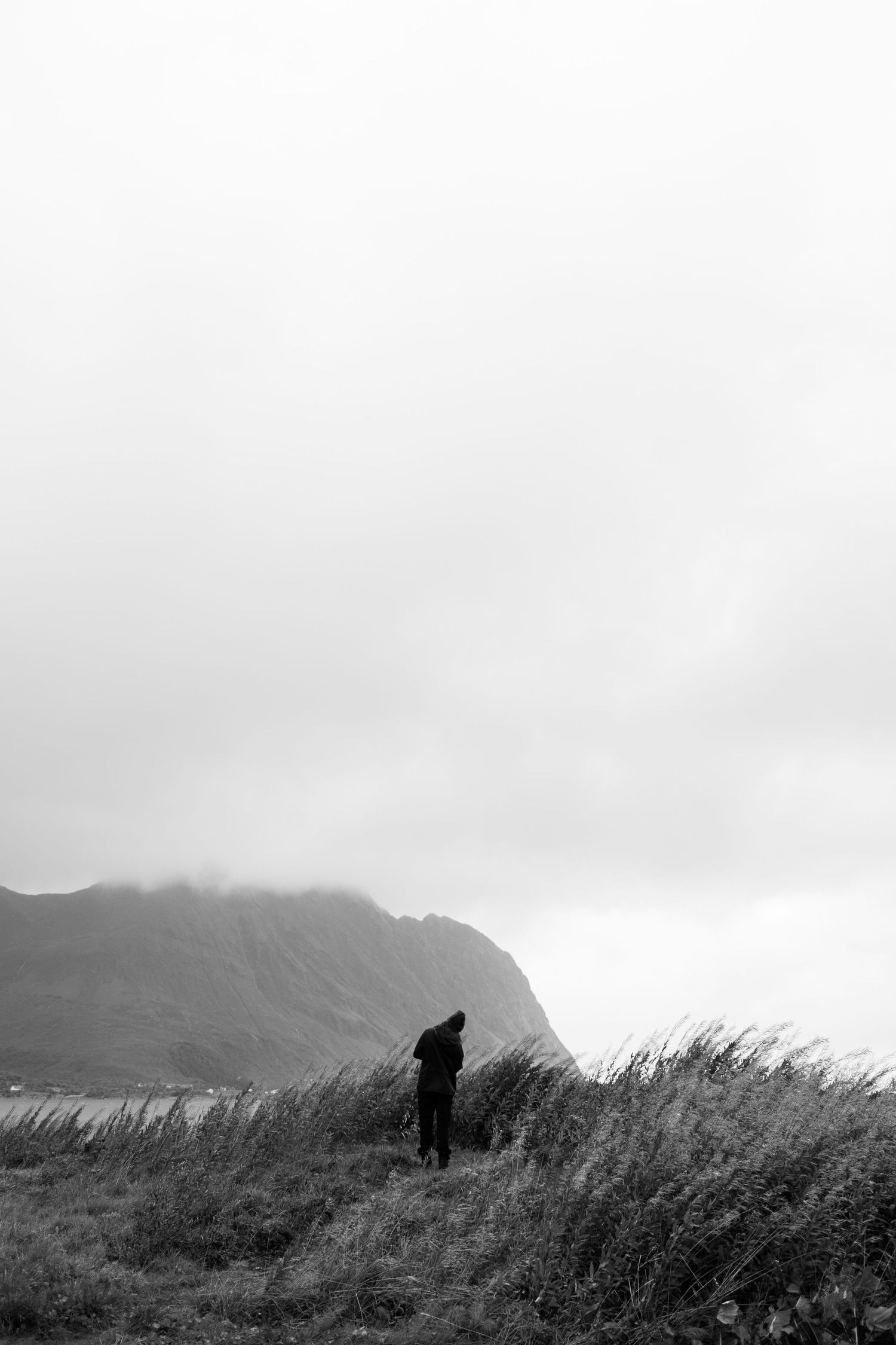 Silhouette of a hiker against misty mountains and dramatic cloudy skies.