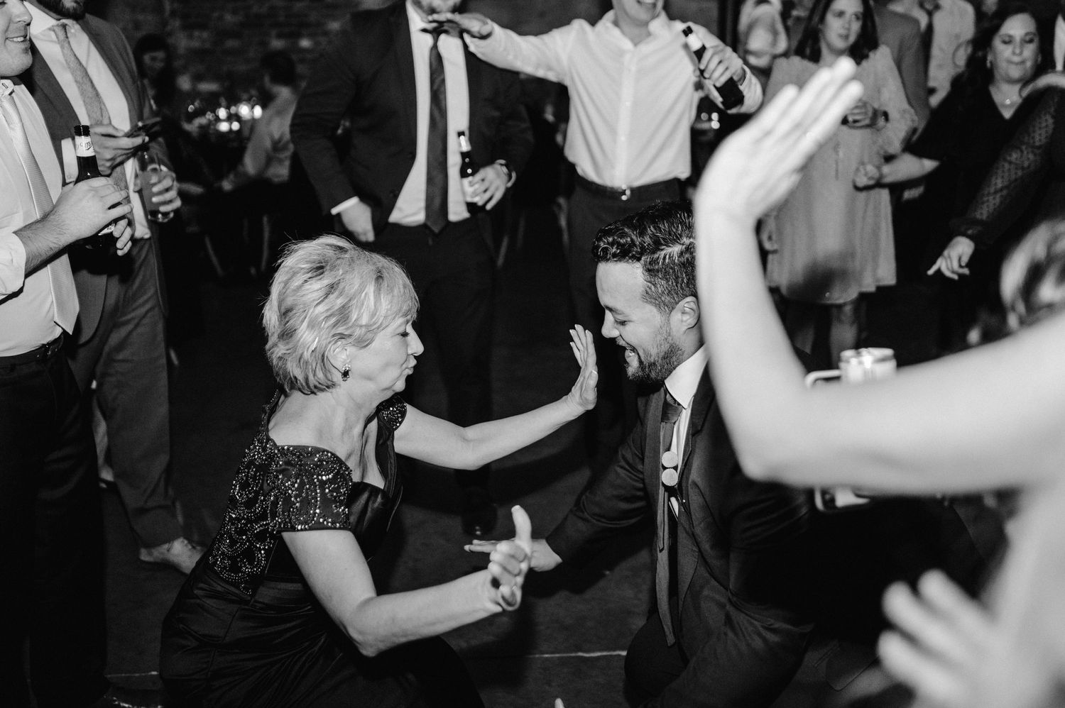 Lively dance floor scene with partygoers dancing in formal attire.