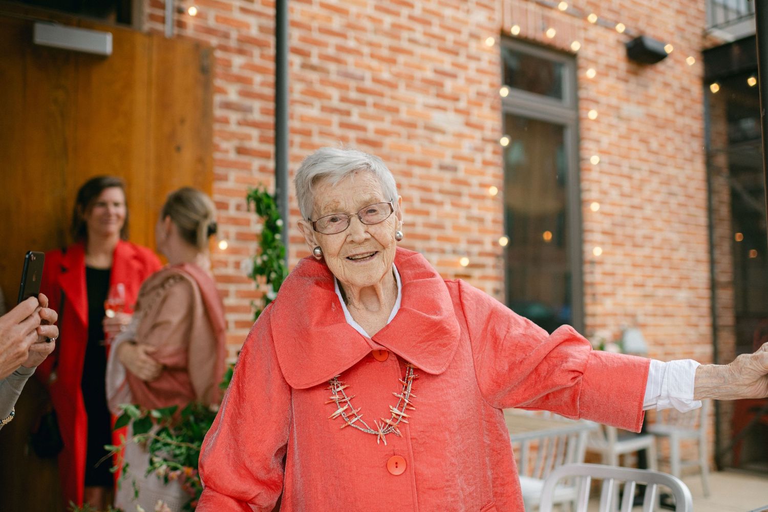 A joyful moment captured outside a brick building entrance during a celebration.