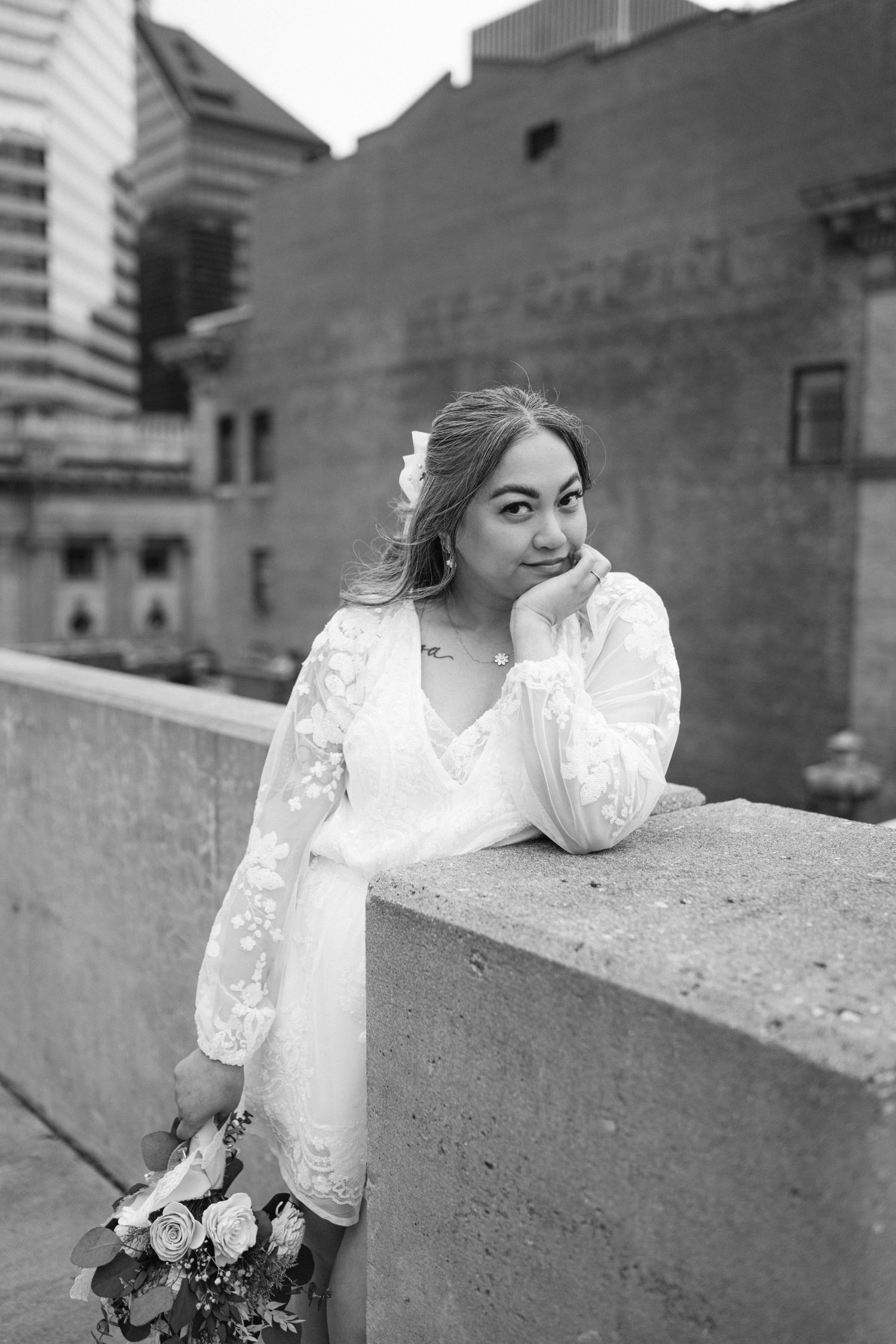 Elegant bridal portrait in black and white showing lace dress details against urban baltimore architecture backdrop.