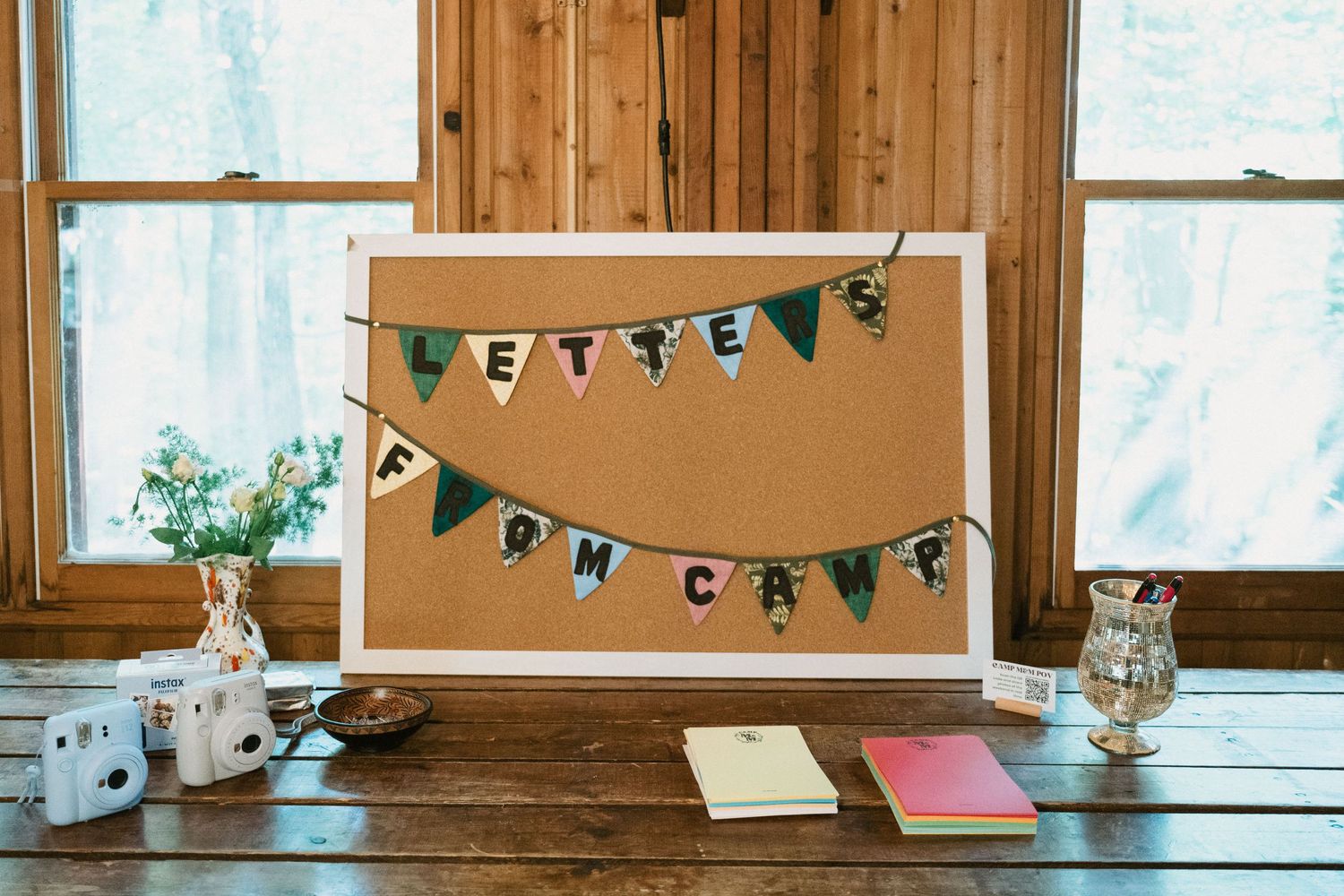 Rustic wedding decor featuring a cork board with banner and mason jar decorations.
