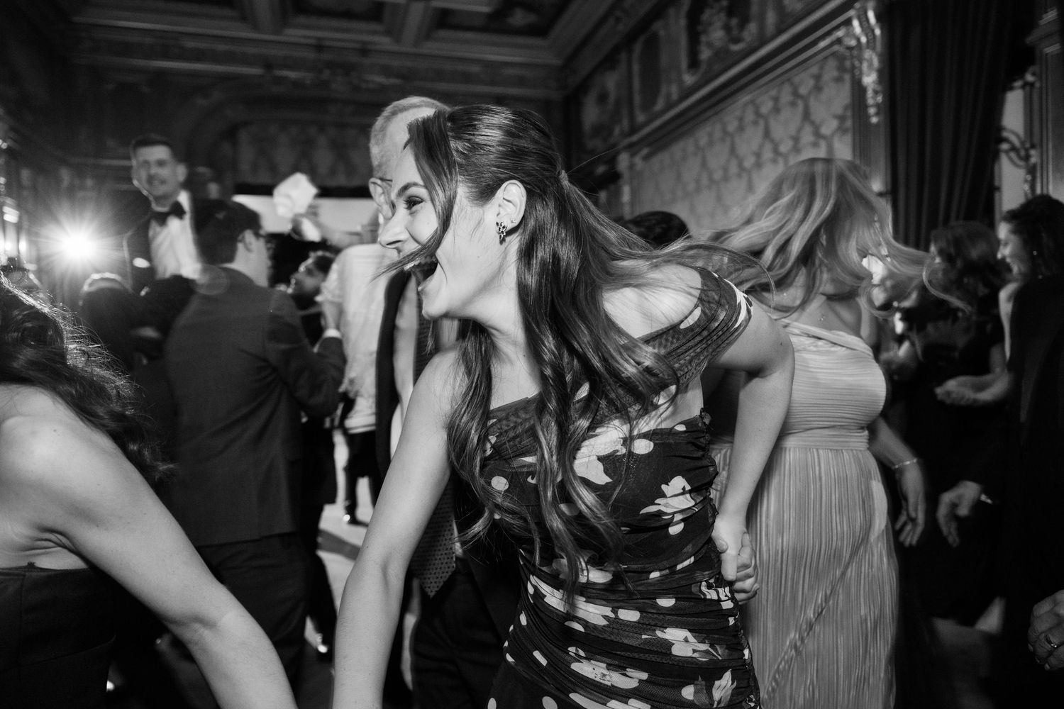 Black and white photo of dancers enjoying a lively reception party.