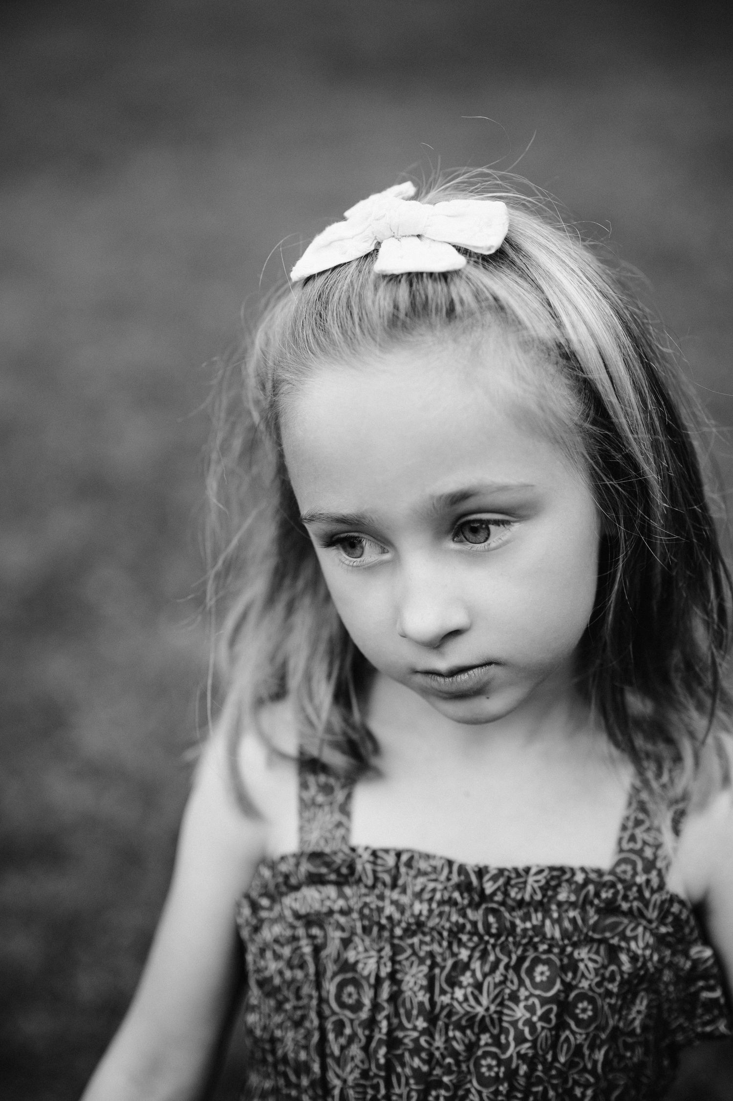 A black and white portrait featuring a bow hair accessory.