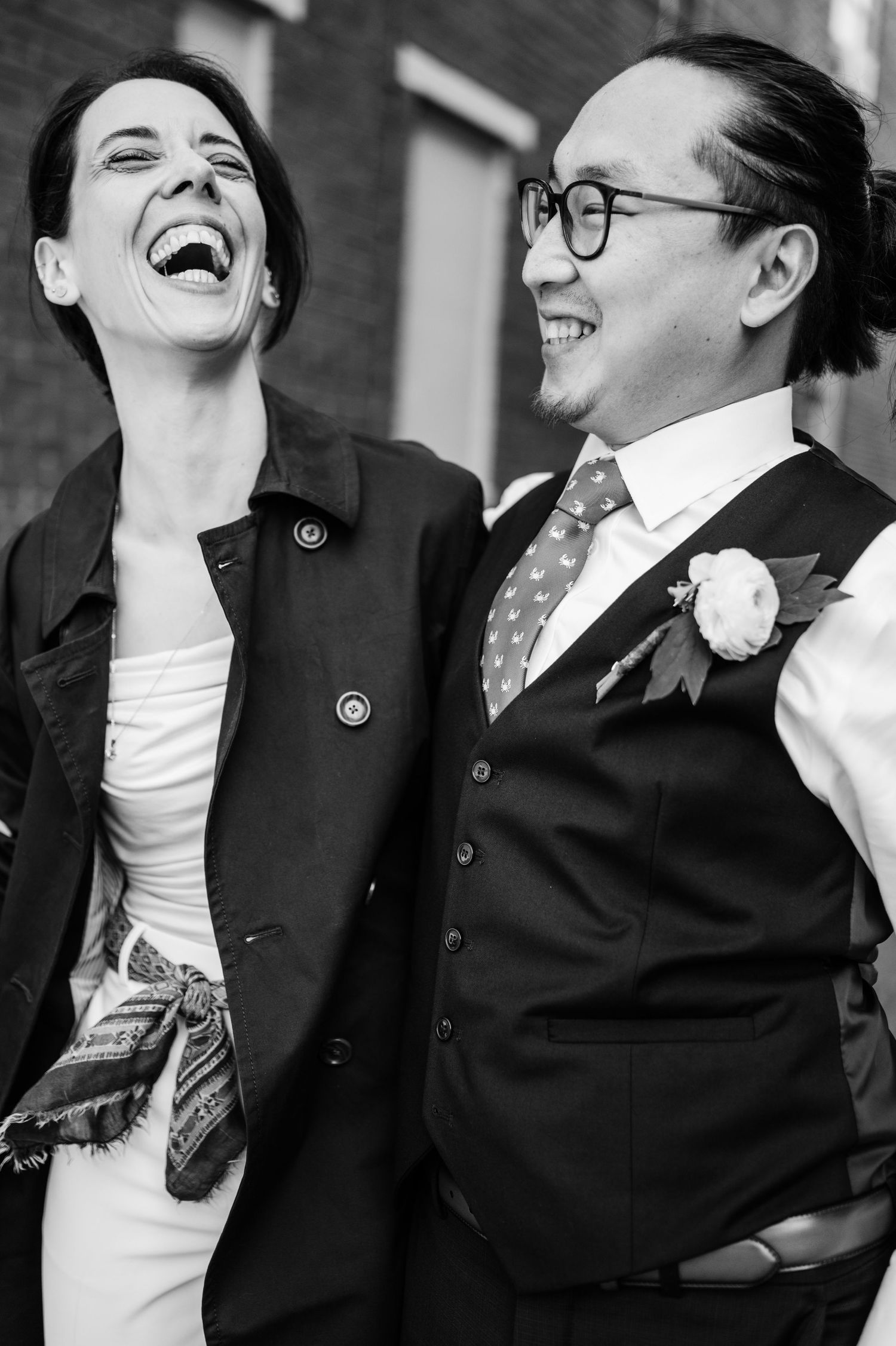 A candid moment of laughter shared between two people in formal wear.