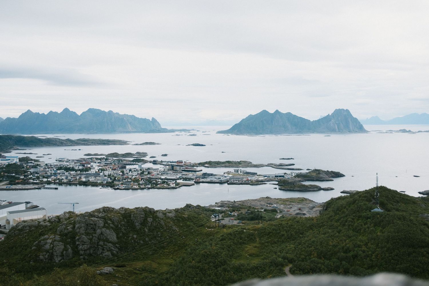Panoramic view of Norwegian coastal town surrounded by mountains and sea.