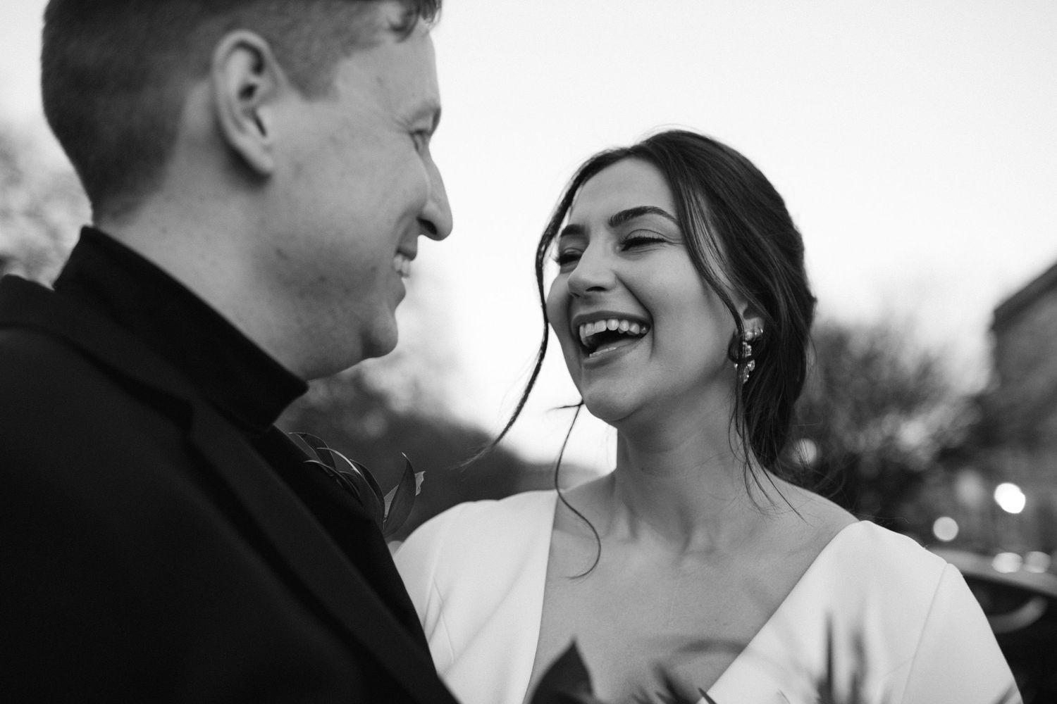 Black and white candid moment of joyful couple sharing laughter.