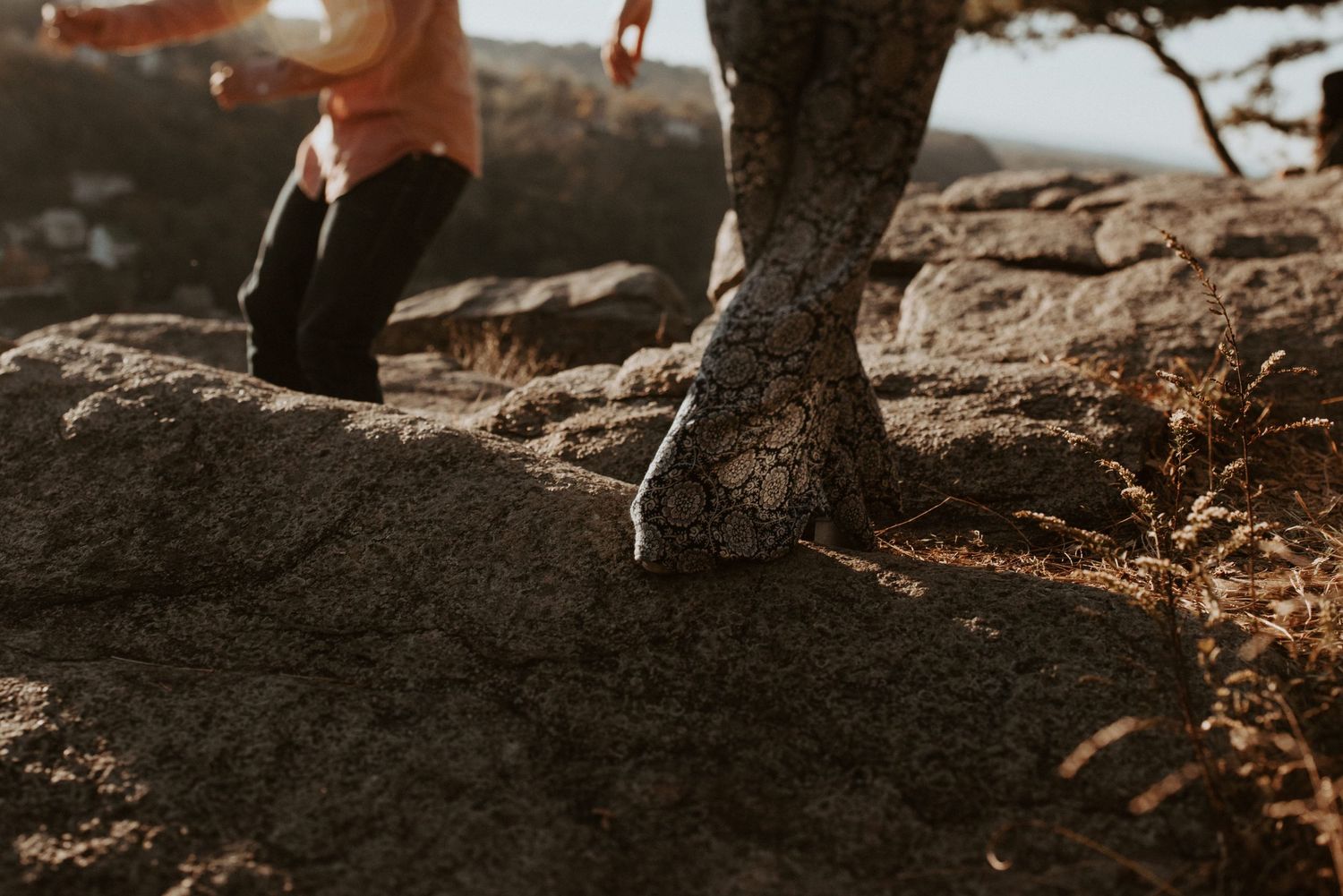 Close-up of hiking boots on rocky terrain during sunset.