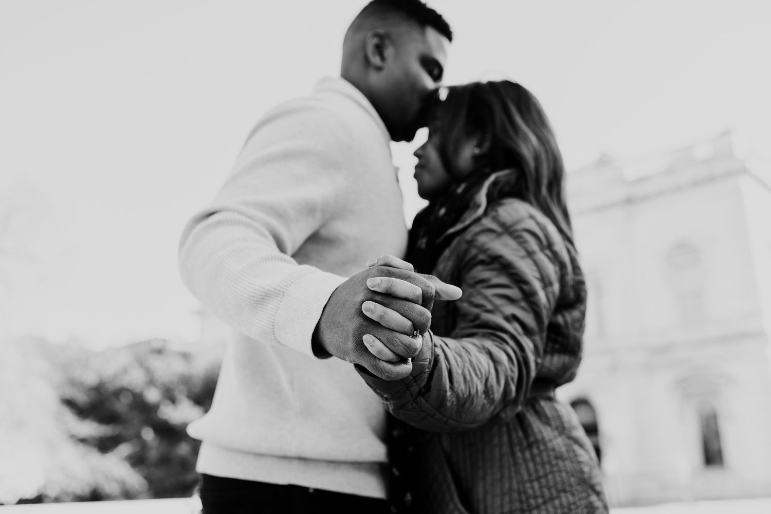 A black and white intimate portrait of a couple sharing a tender moment.