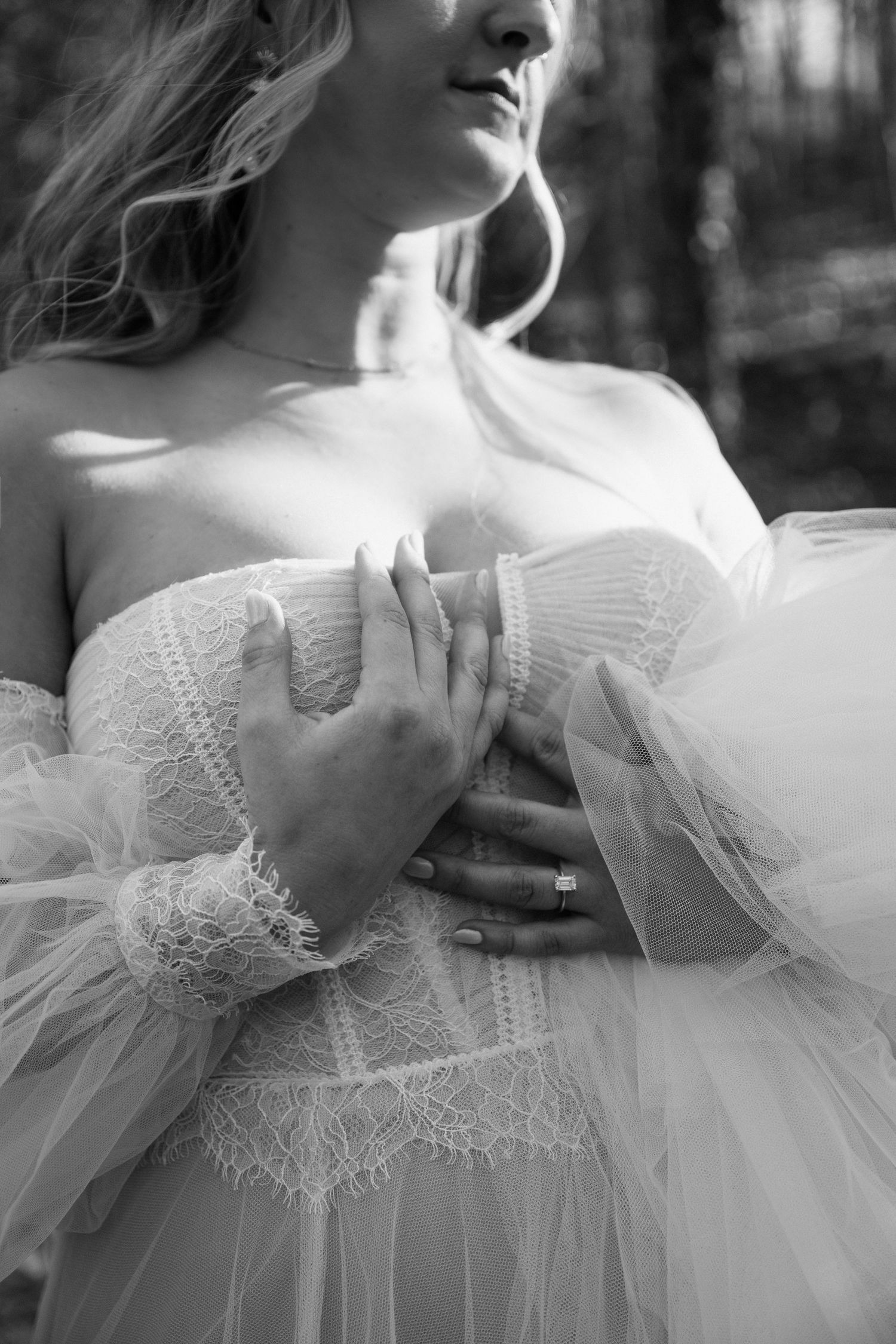 Close-up detail of delicate lace and tulle on a white wedding dress.