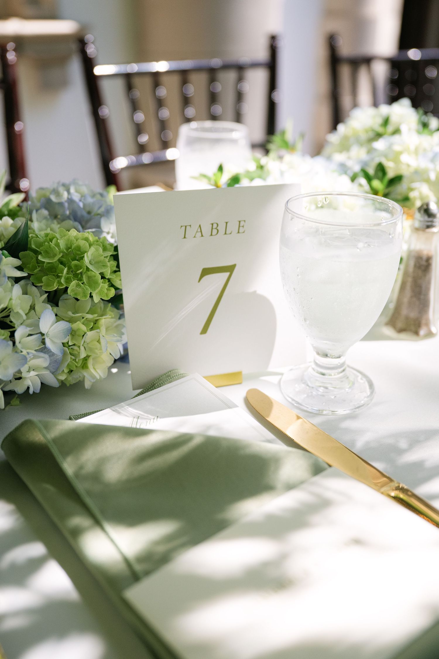 Elegant wedding table setting with floral centerpieces and table number seven.