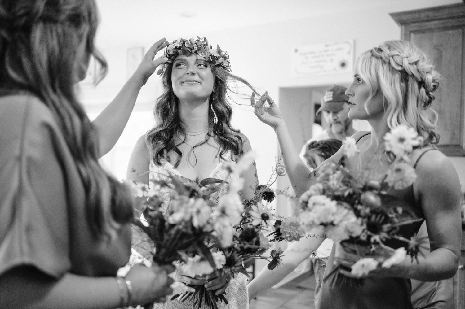 Black and white photo of wedding preparations with flower crowns and bouquets.