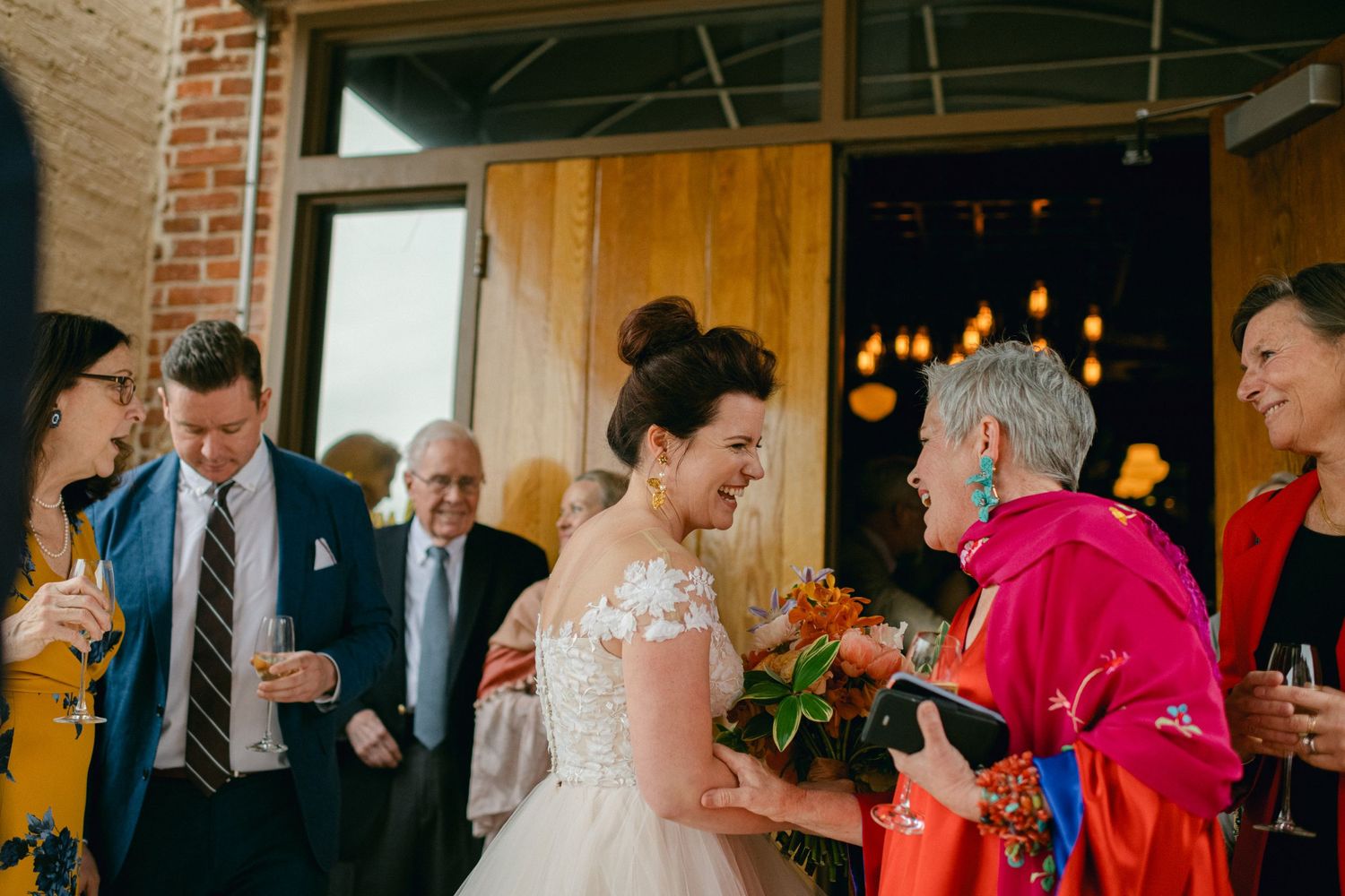 A celebratory wedding reception scene with guests mingling in a warmly lit venue.