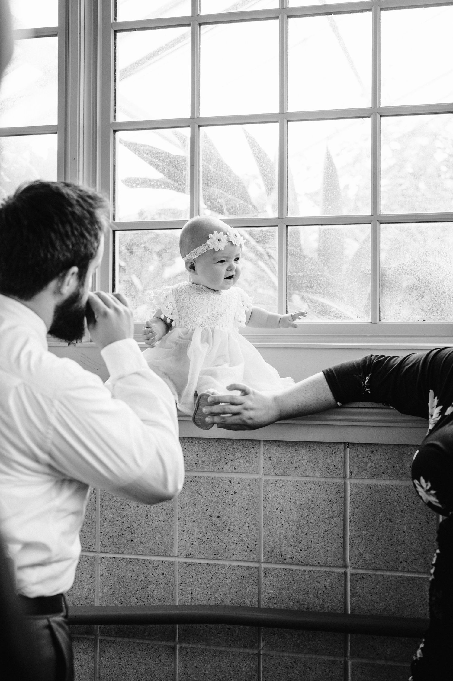 A tender family moment captured by a window with natural light streaming in.