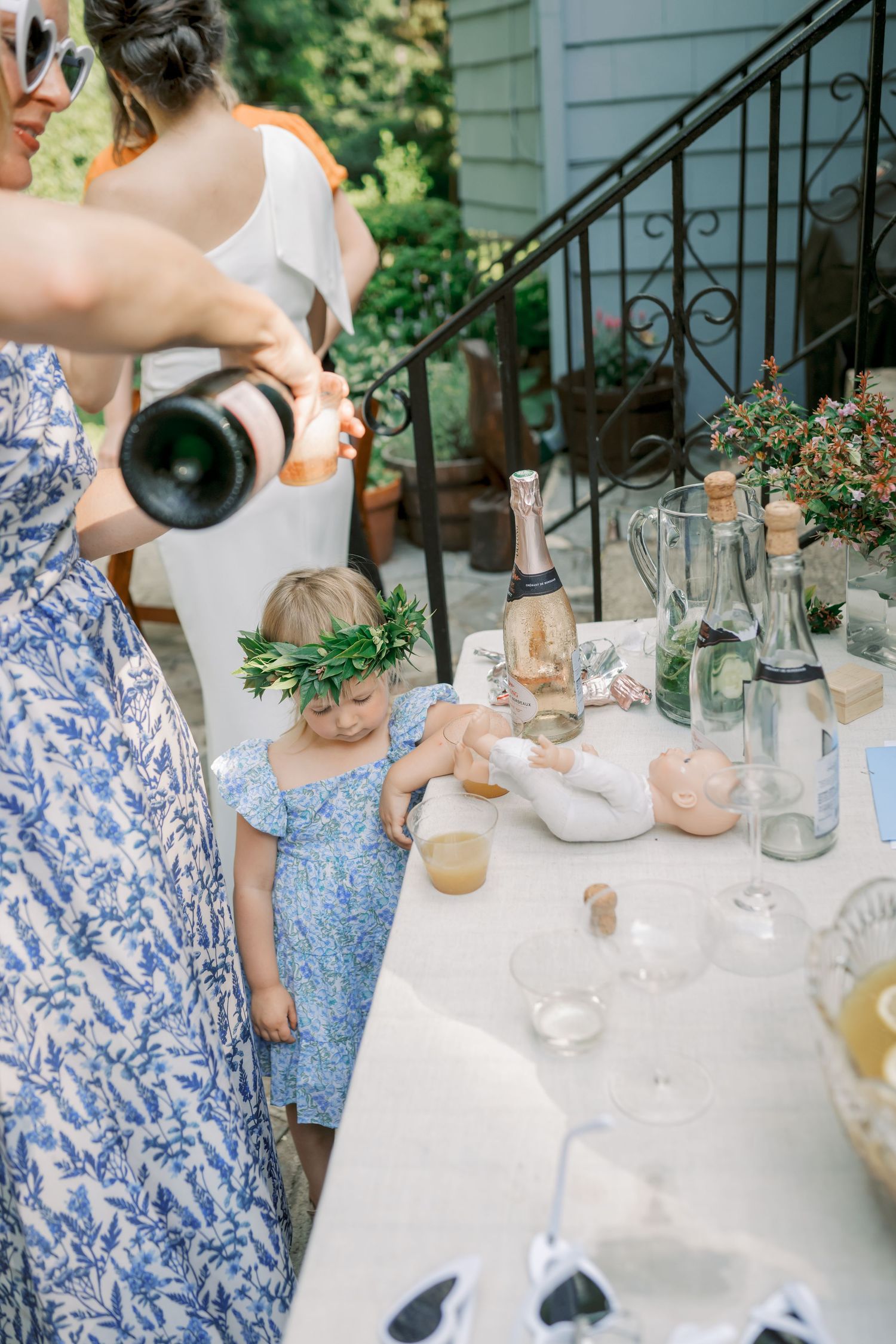 Garden party table setting with blue floral patterns and glassware in natural light.