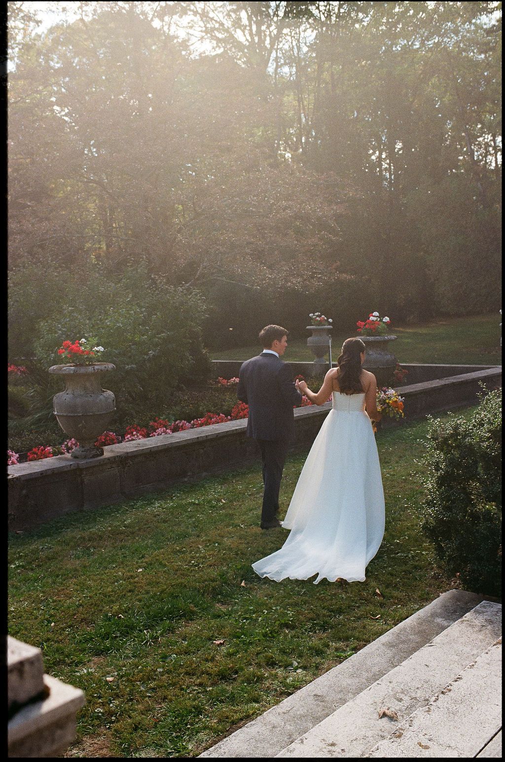 A couple stands together in a misty garden setting during golden hour at their wedding at Strong Mansion on Sugarloaf Mountain