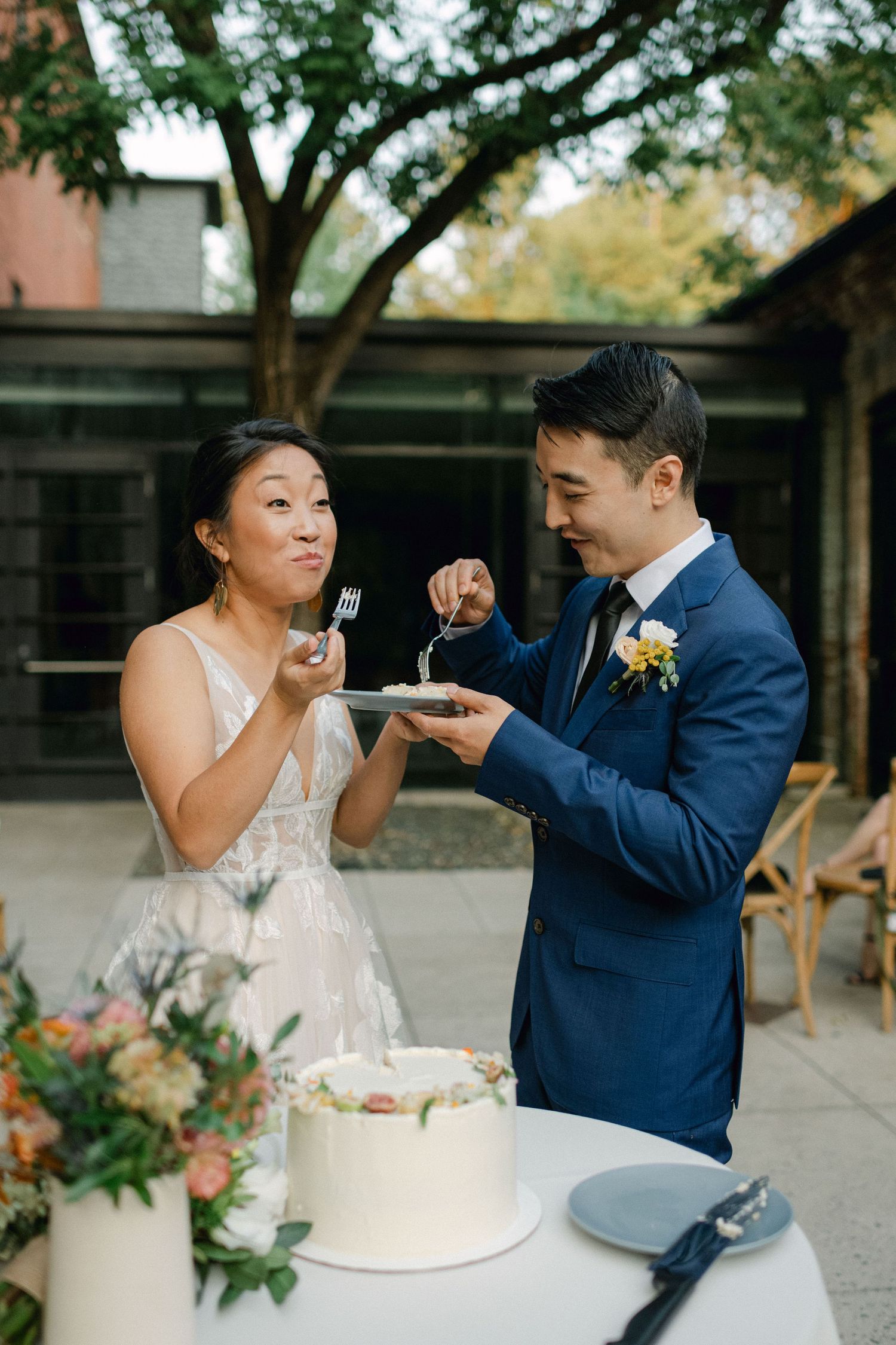 bride and groom cut the wedding cake and share a bit3e