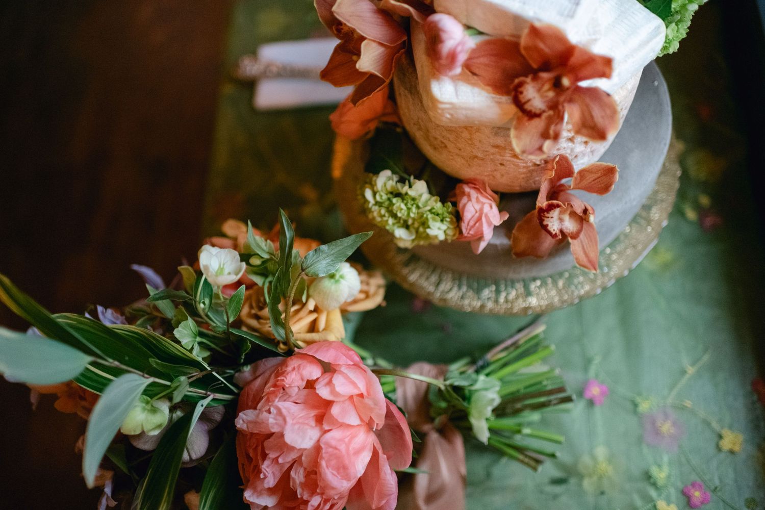 Close-up of pink peonies and floral arrangements at a wedding reception.