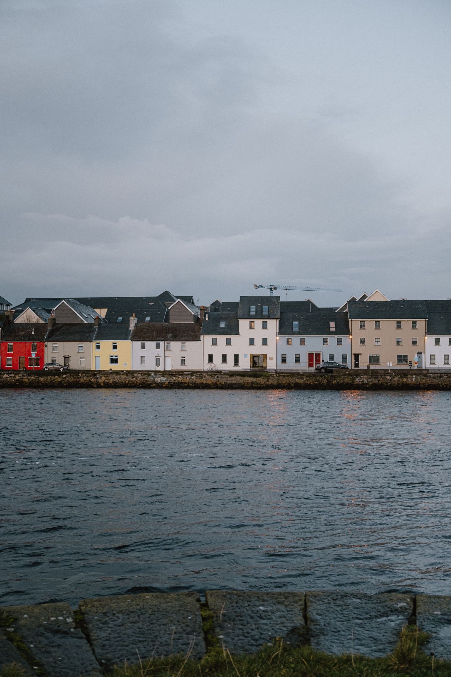 Row of colorful waterfront houses along the harbor in a coastal Irish town.