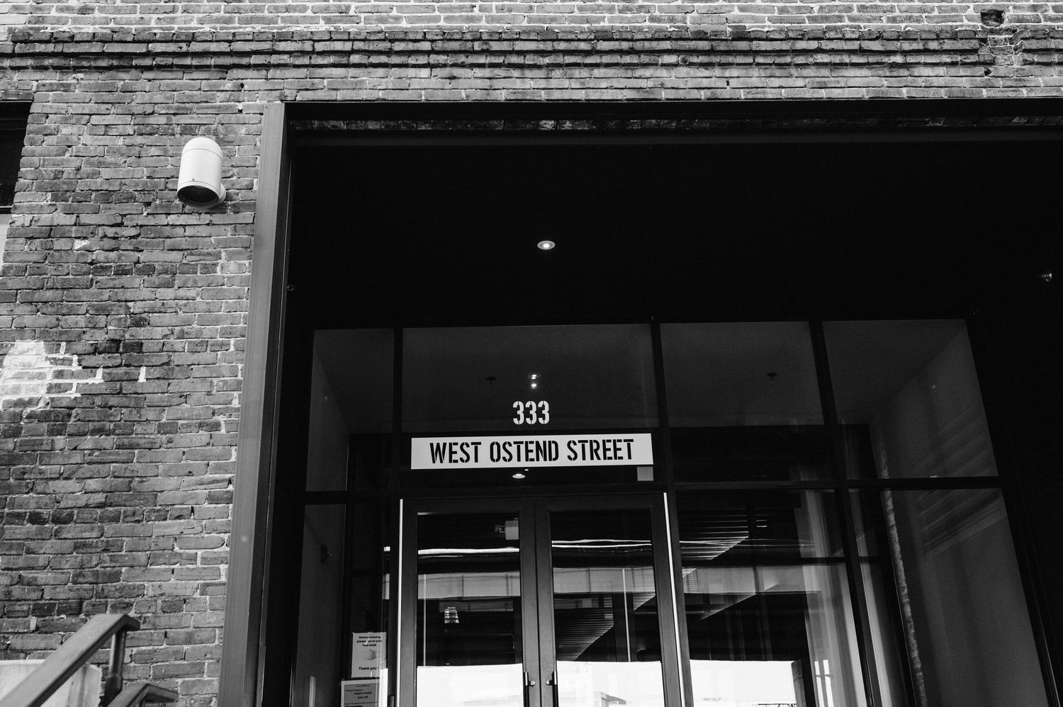 Black and white architectural detail of brick building entrance with address number.