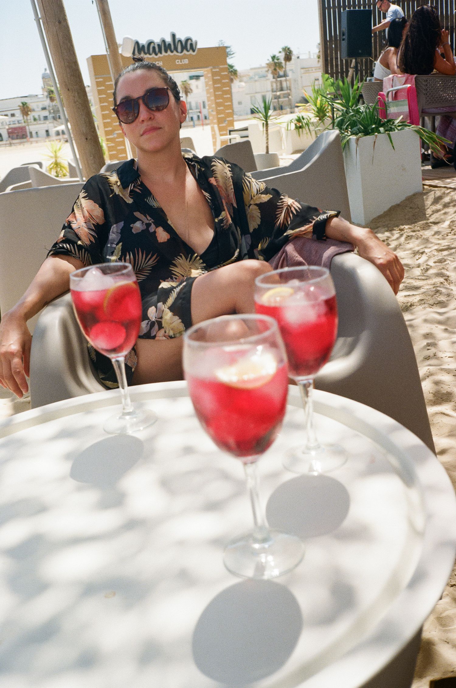 Red cocktails served on white tablecloth at outdoor beachside restaurant.