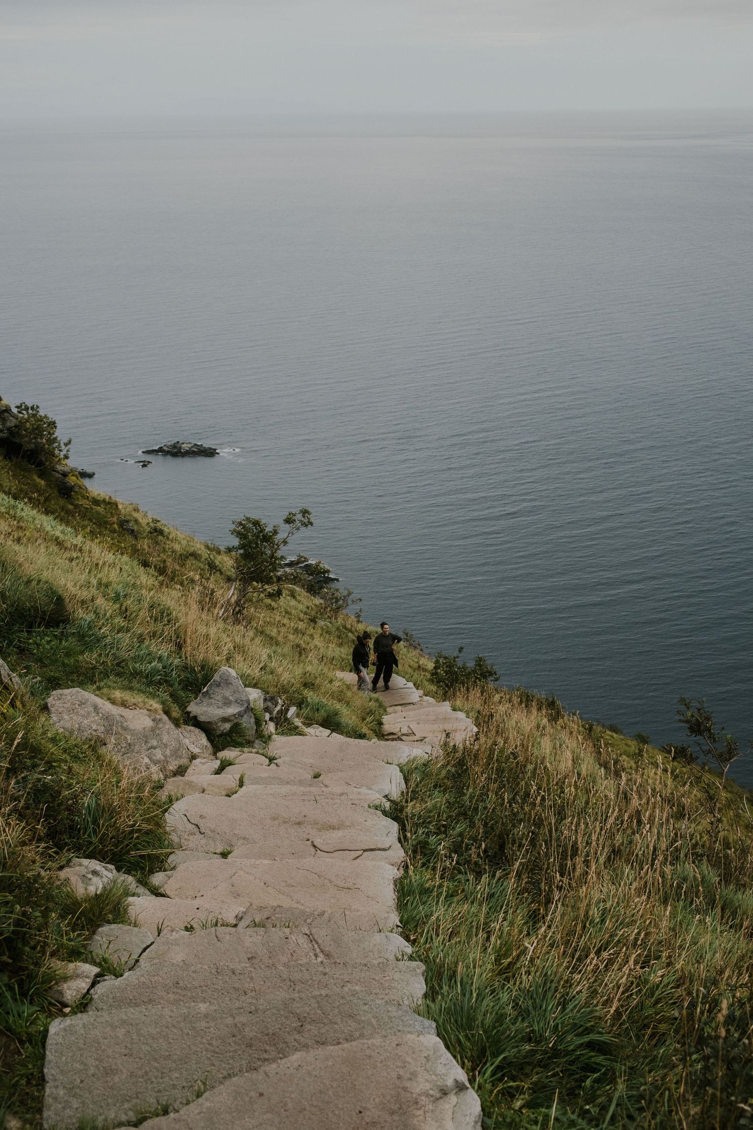 Stone steps winding down a coastal hillside with ocean views in Norway.