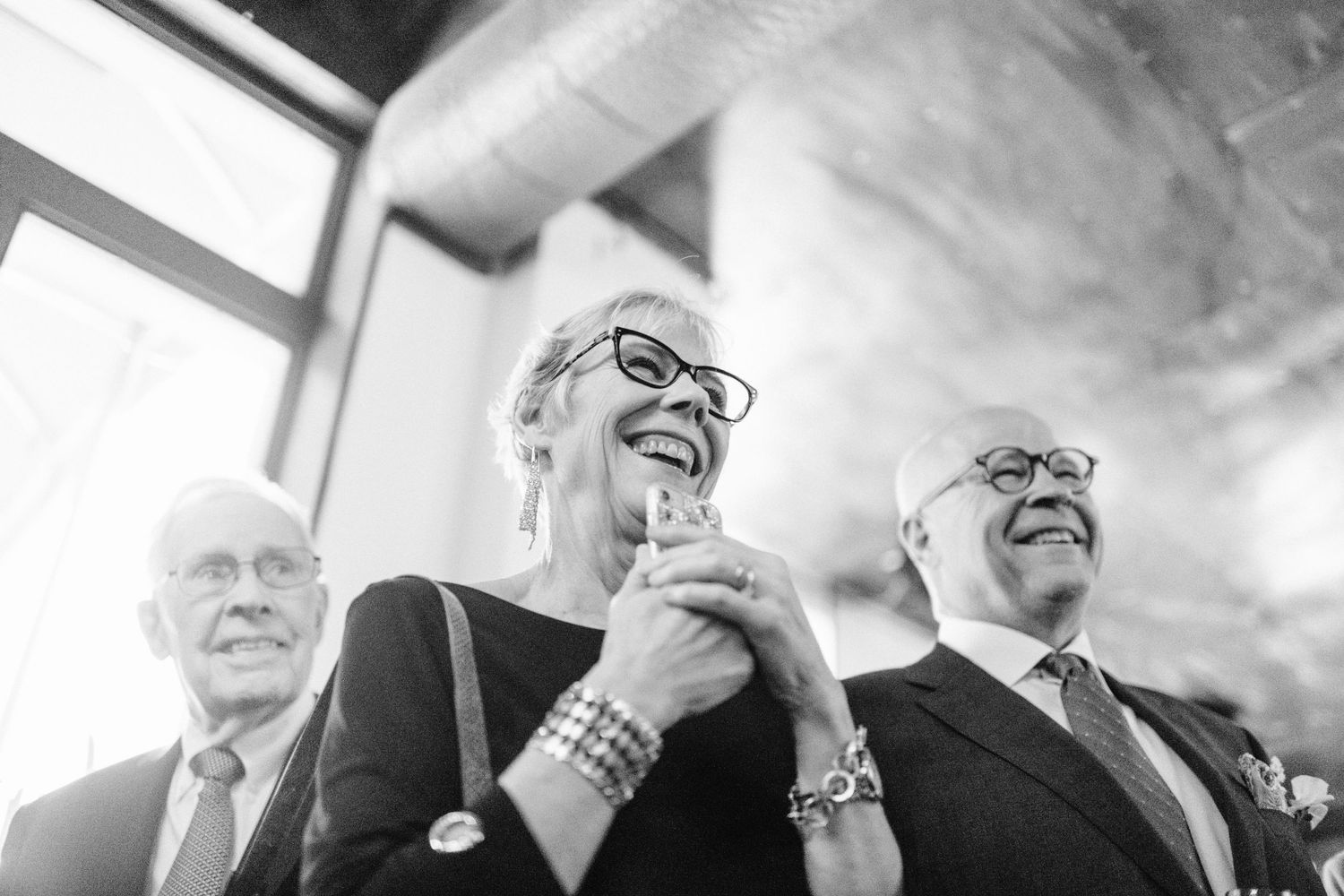 Wedding guests share joyful reactions during an emotional ceremony moment.
