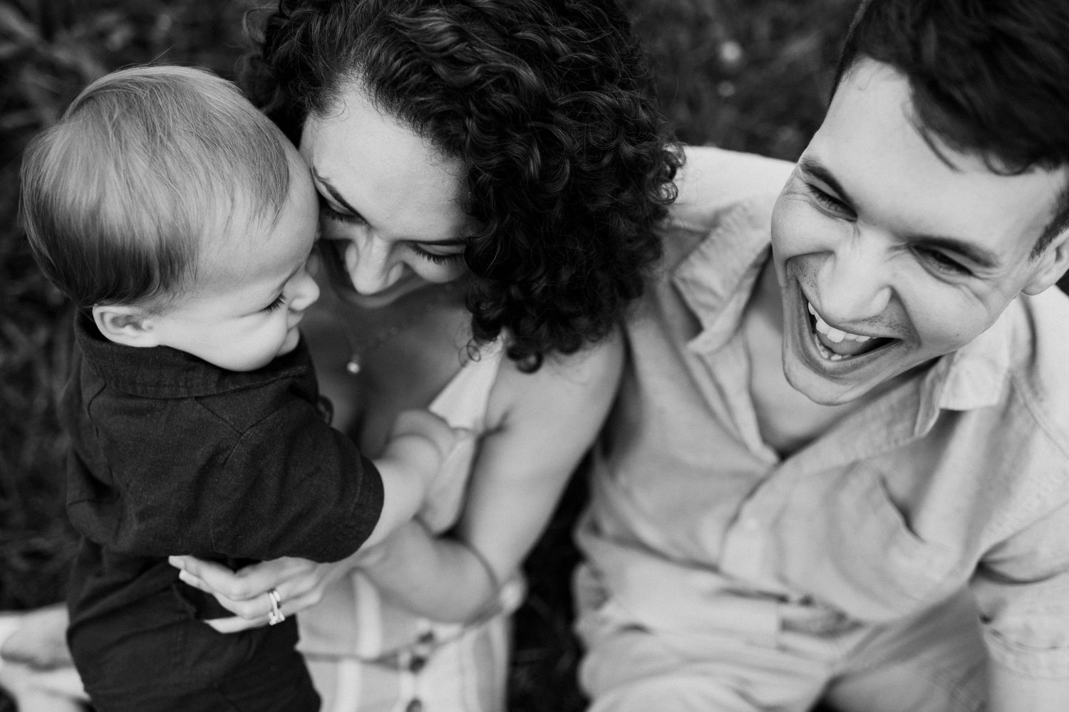 Candid black and white photo capturing joyful family moment outdoors.