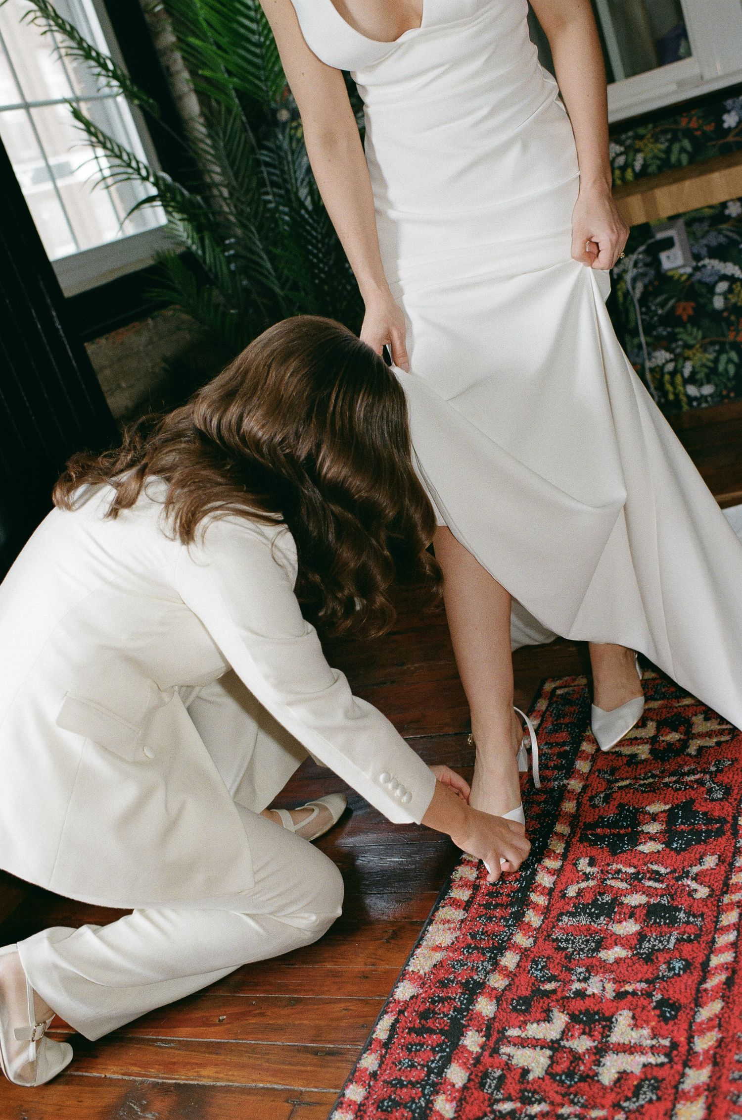 A series of photos showing white dress and shoes on a vintage patterned red and black rug on hardwood flooring.