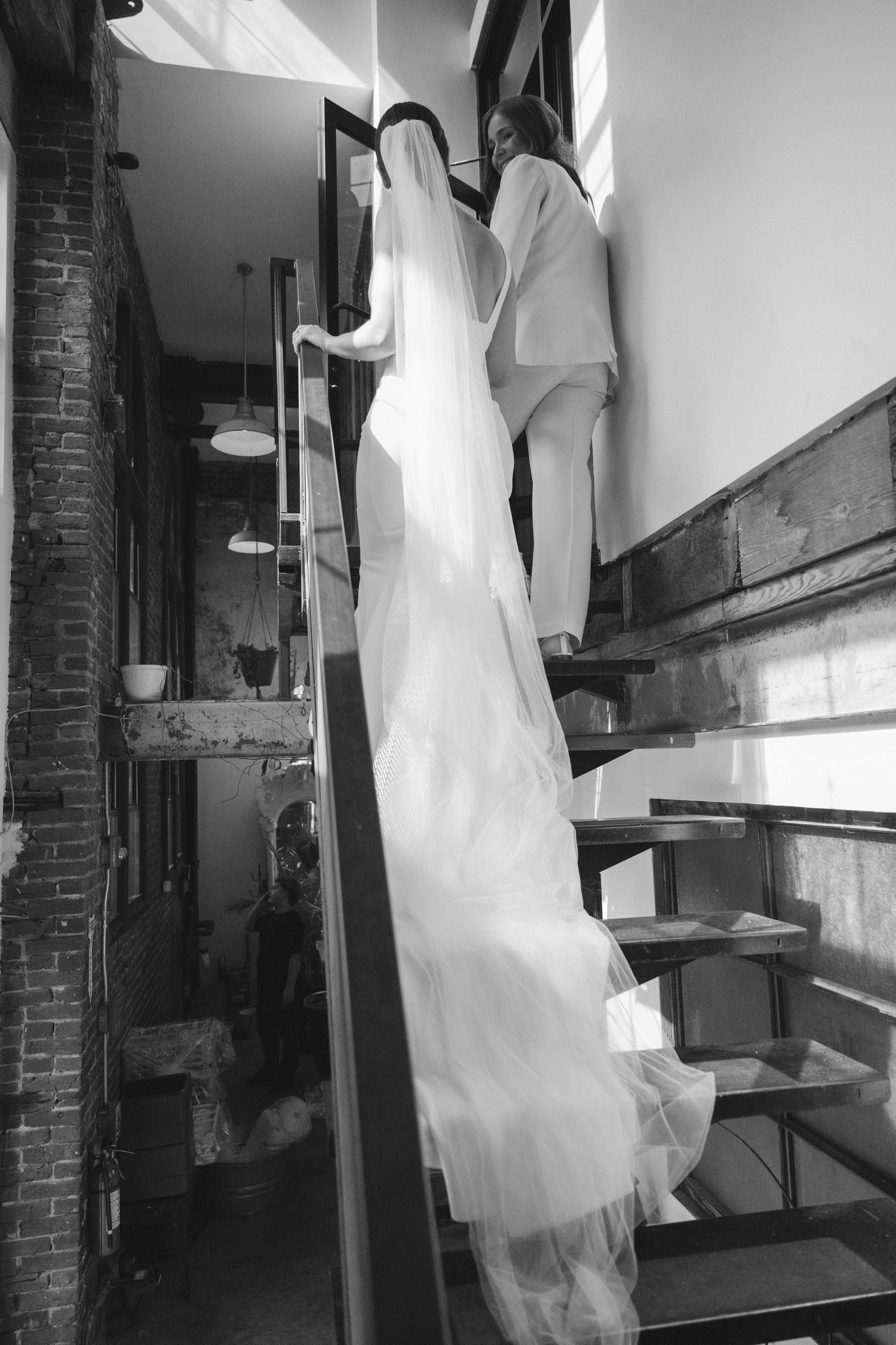 Industrial style venue interior with exposed brick walls and hanging white fabric.