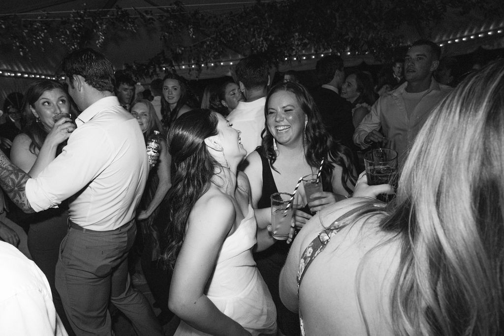 Black and white photo captures guests dancing and celebrating at a wedding reception at Strong Mansion on Sugarloaf Mountain