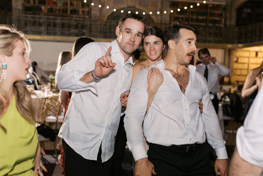 Guests enjoying themselves on a dance floor under string lights at a wedding celebration.