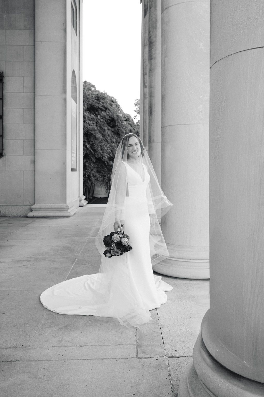 A black and white triptych shows a bride in a flowing veil moving between classical stone columns in an elegant pose.