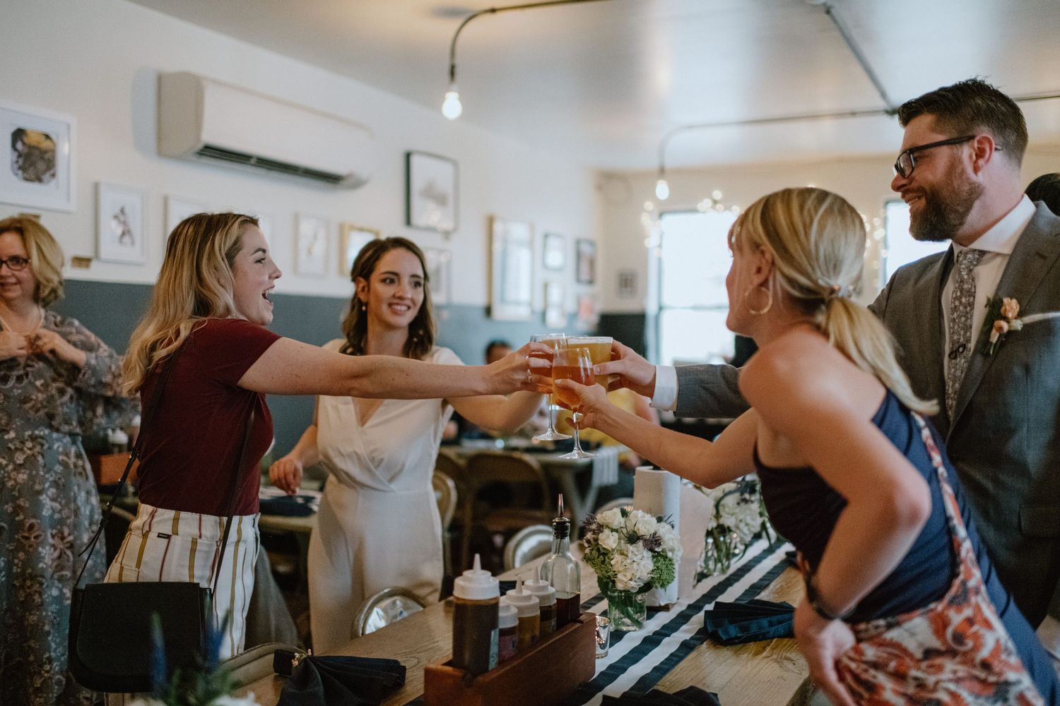 Wedding guests celebrate and raise glasses during a lively reception toast.