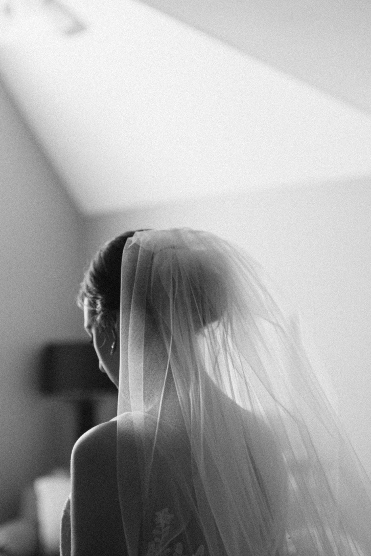 Artistic black and white shot of a bridal veil in dramatic lighting.