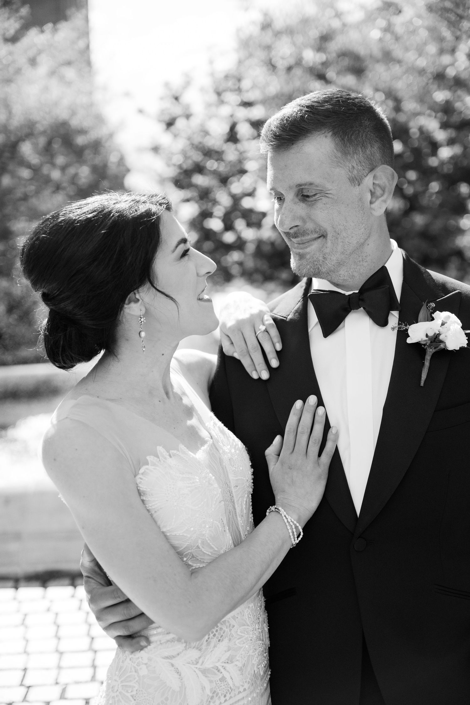Couple in formal wedding attire embracing outdoors in romantic black and white series of photos.