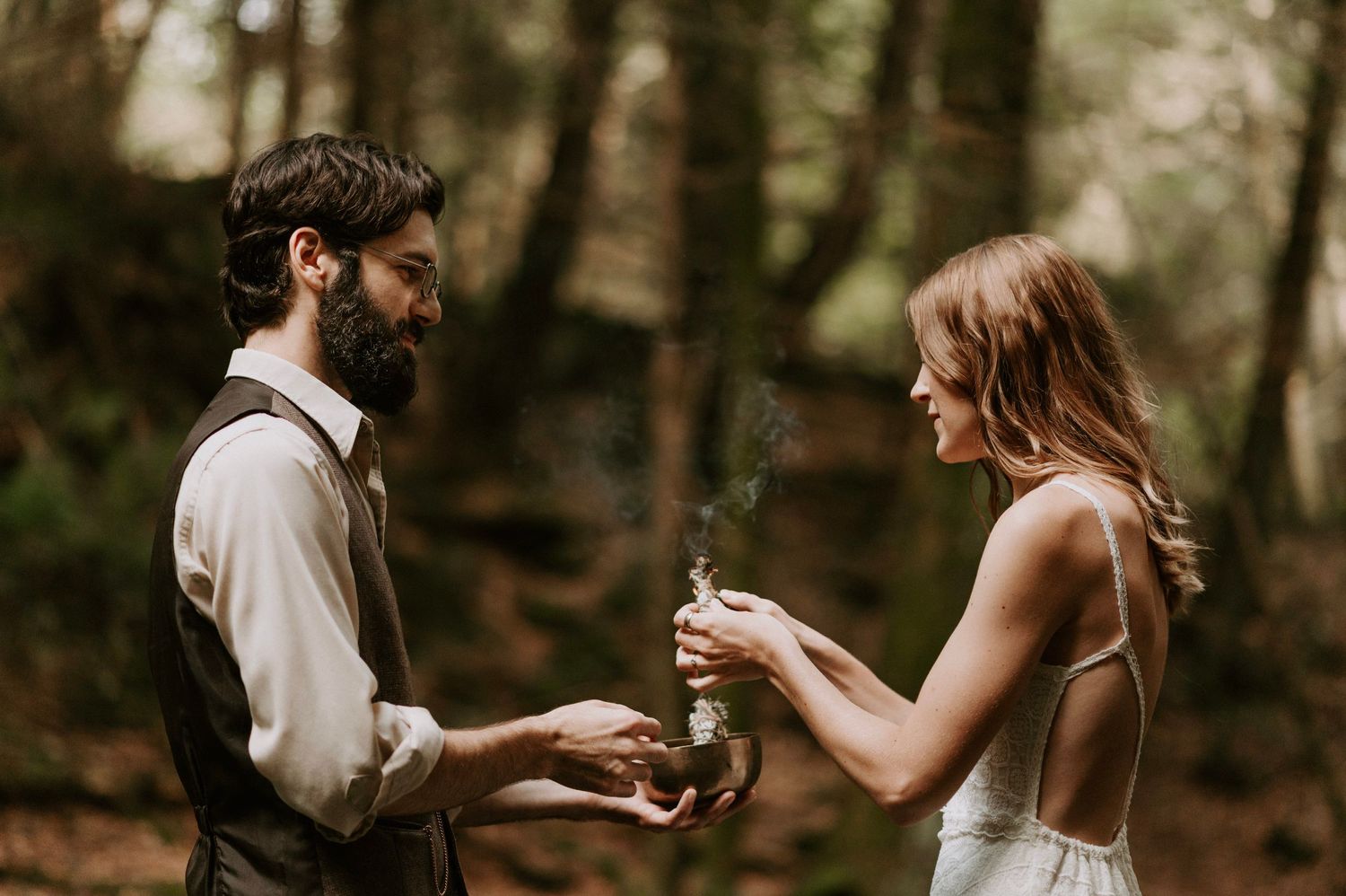 A couple shares drinks during an intimate forest ceremony.