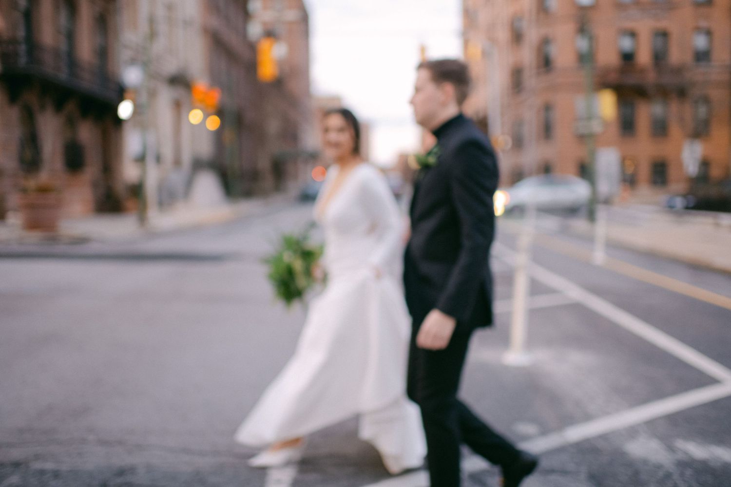 Artistic blurred shot of wedding couple walking down urban street.