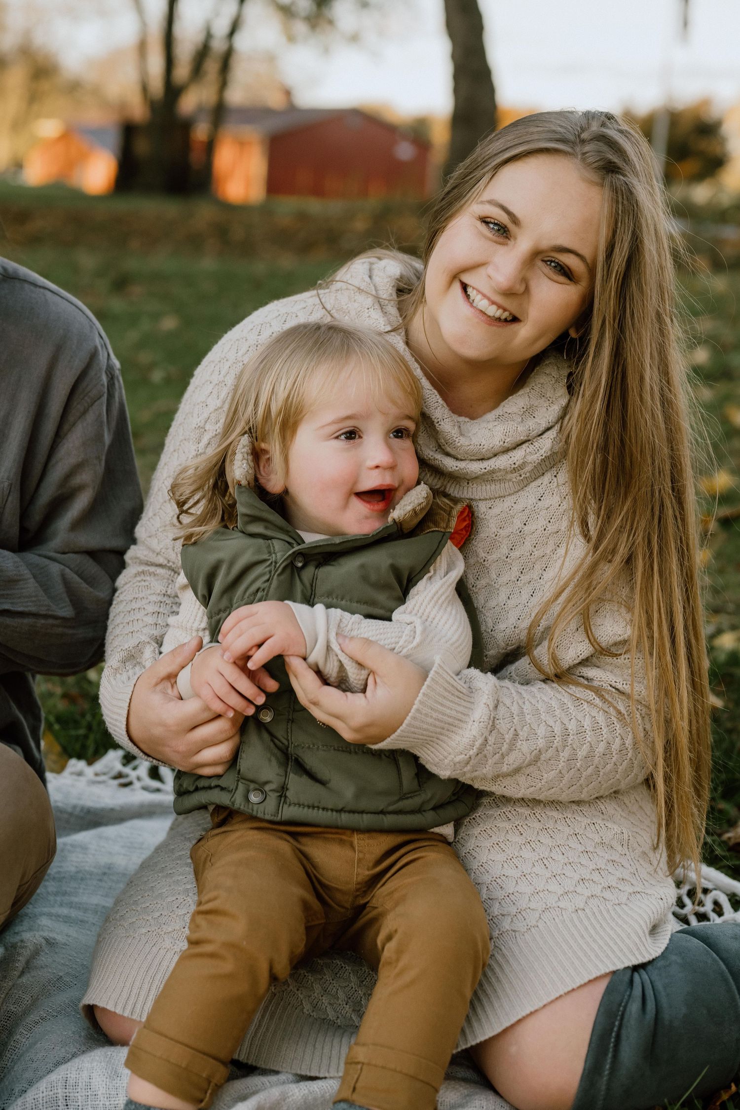 A joyful outdoor autumn portrait captured on a cozy blanket.