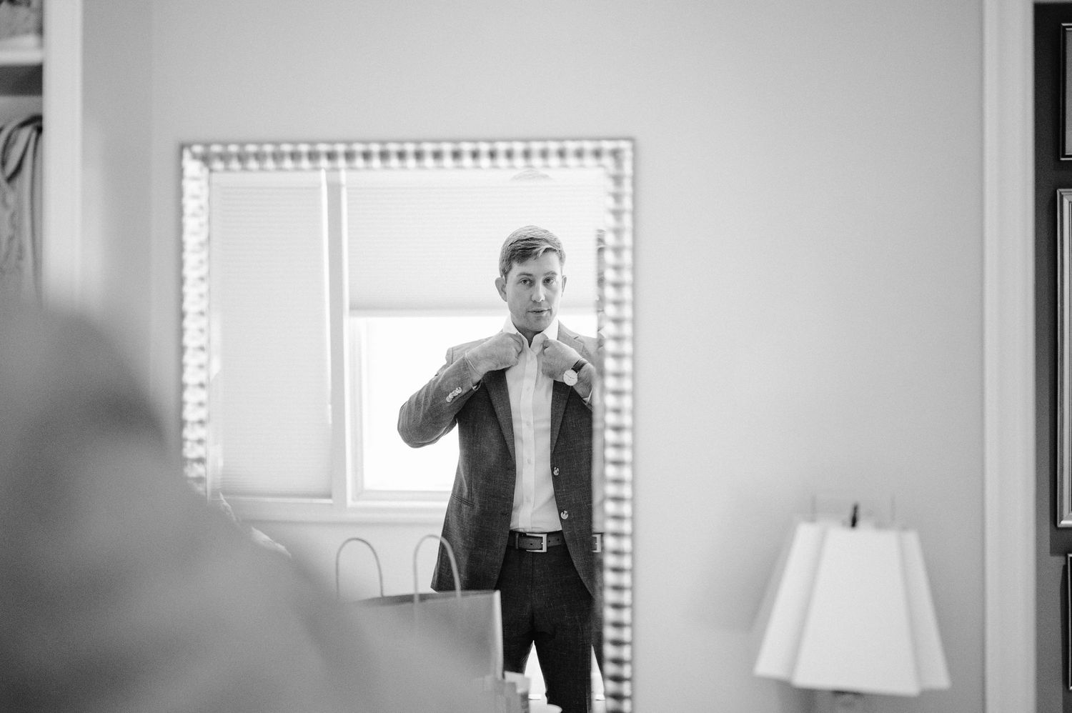 Getting ready scene reflected in a mirror with vanity lights.