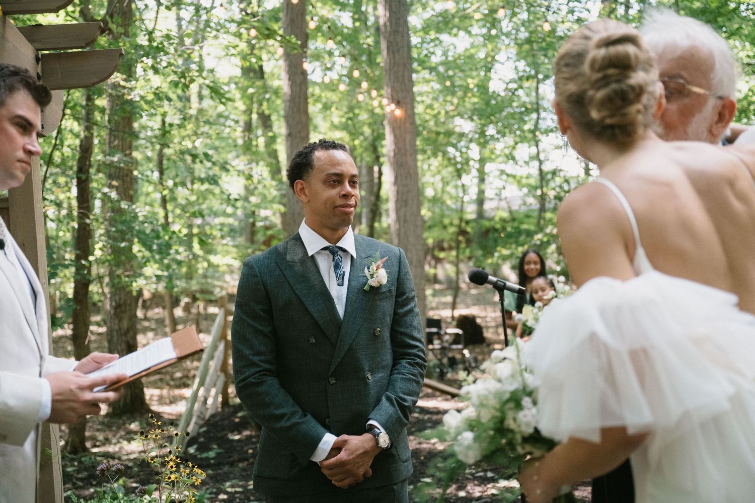 groom smiles at bride as she stands near the altar