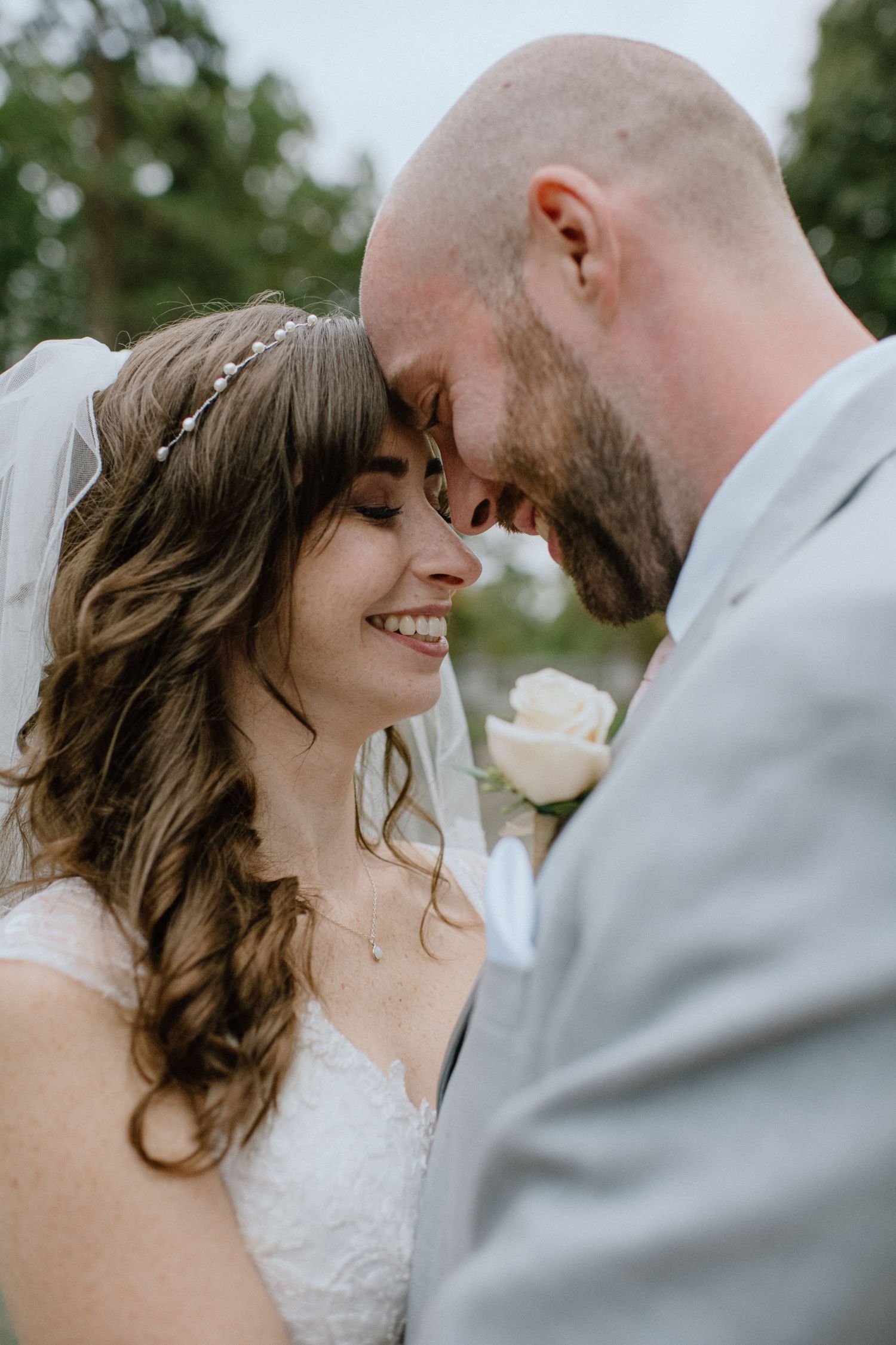 Intimate moment between newlyweds as they share a close embrace outdoors.