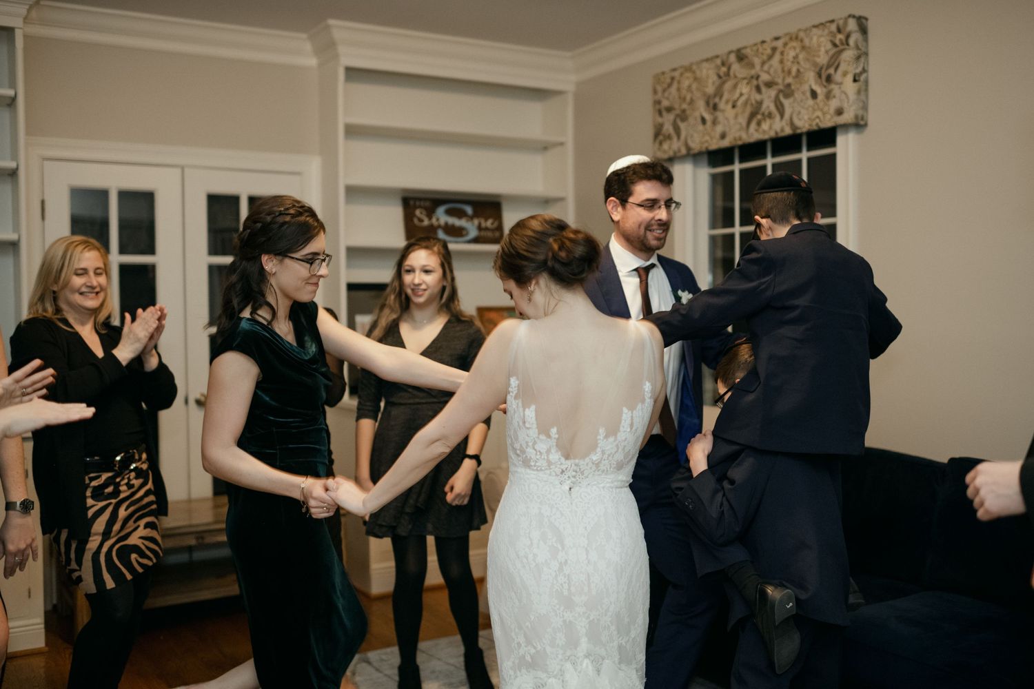 Wedding party dancing and celebrating during evening reception.