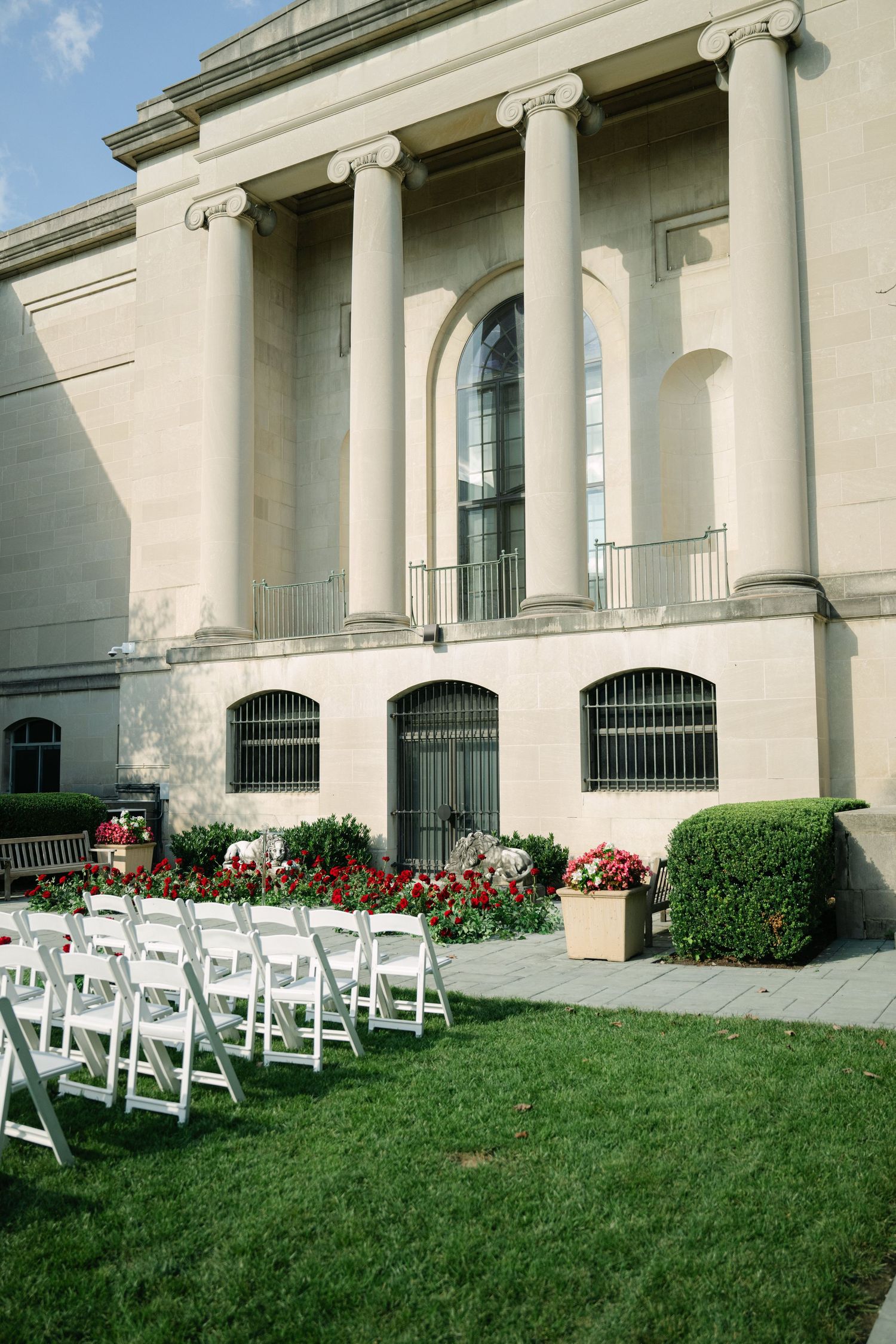 Classical building facade with white columns and outdoor wedding ceremony setup.