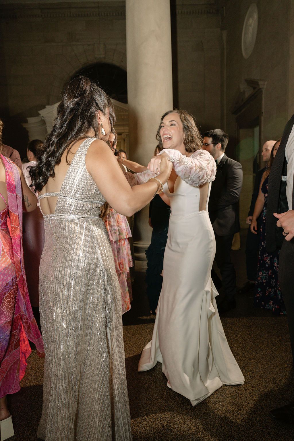 Wedding reception dance floor scene with guests in formal attire dancing and celebrating.
