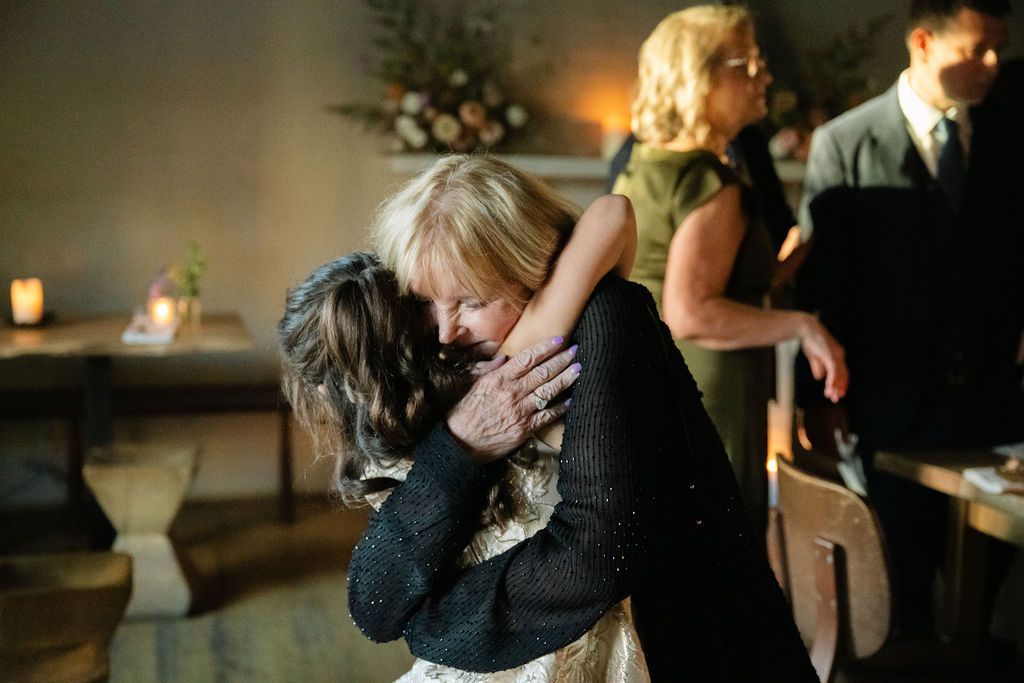 Emotional candid moment between guests dancing at an evening celebration.