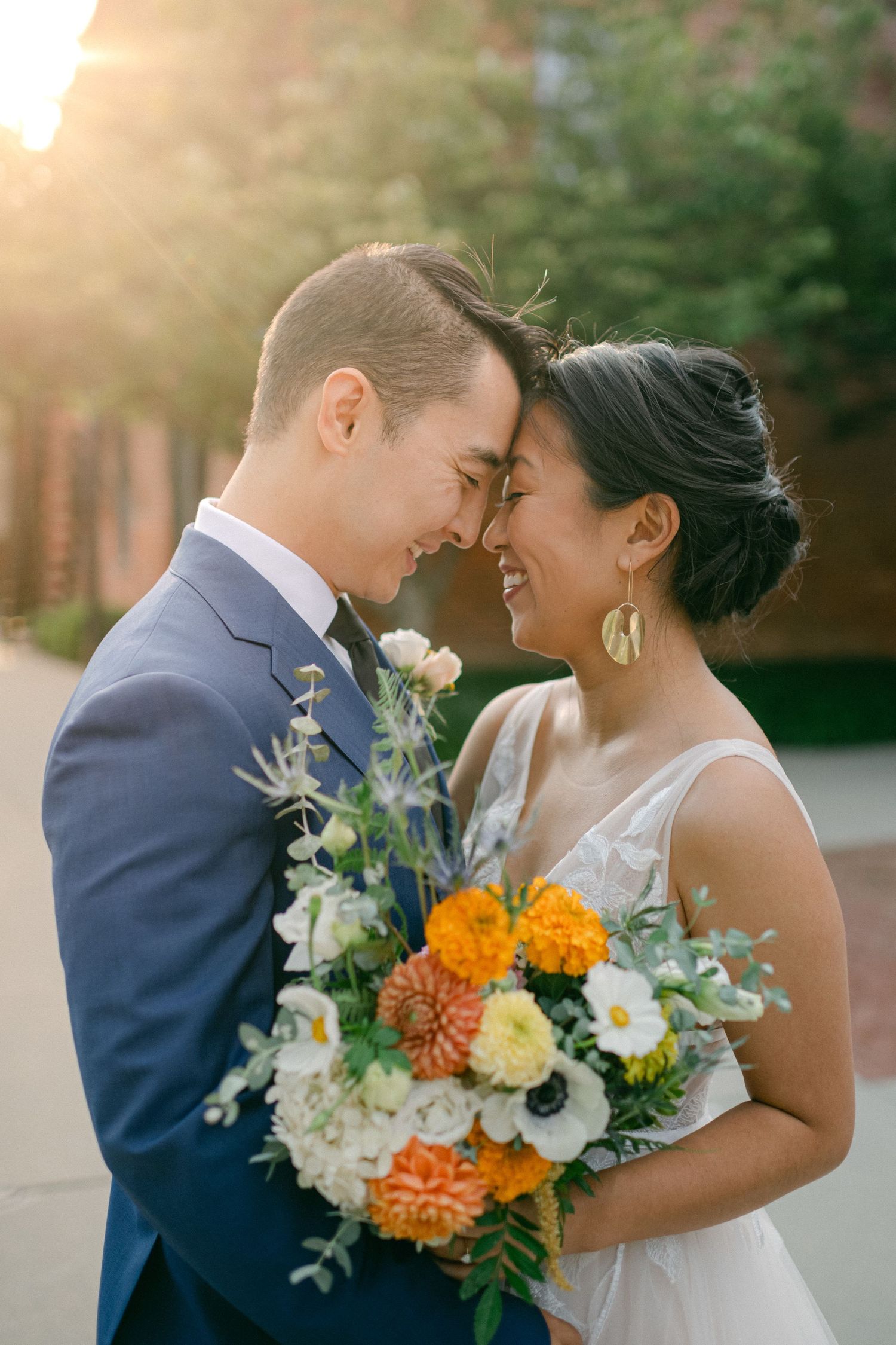 beautiful sun flare lights bride and groom as they smile on their wedding day
